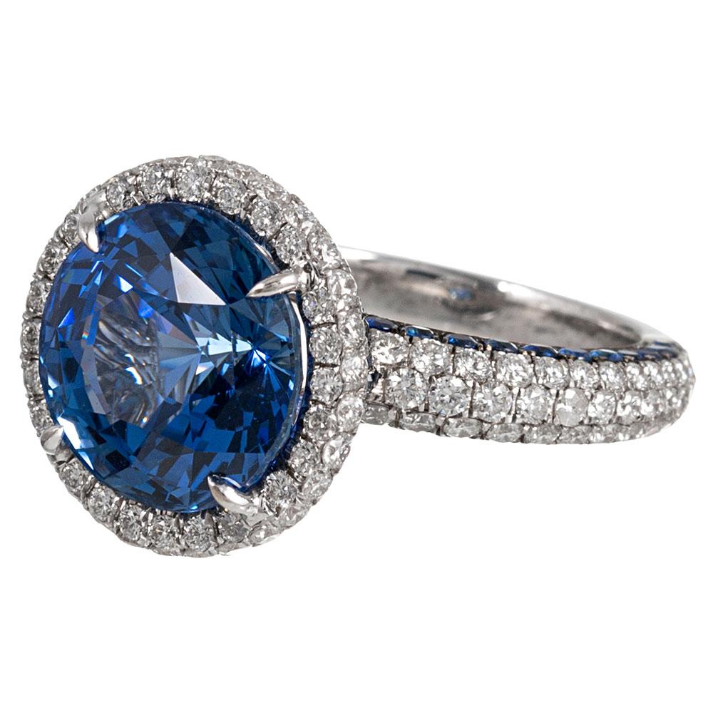 Exceptionally detailed and the design executed with masterful skill, the centerpiece of this ring is a faceted round sapphire of 8.58 carats. The stone is encircled by a single row of brilliant white diamonds and beautifully finished with further