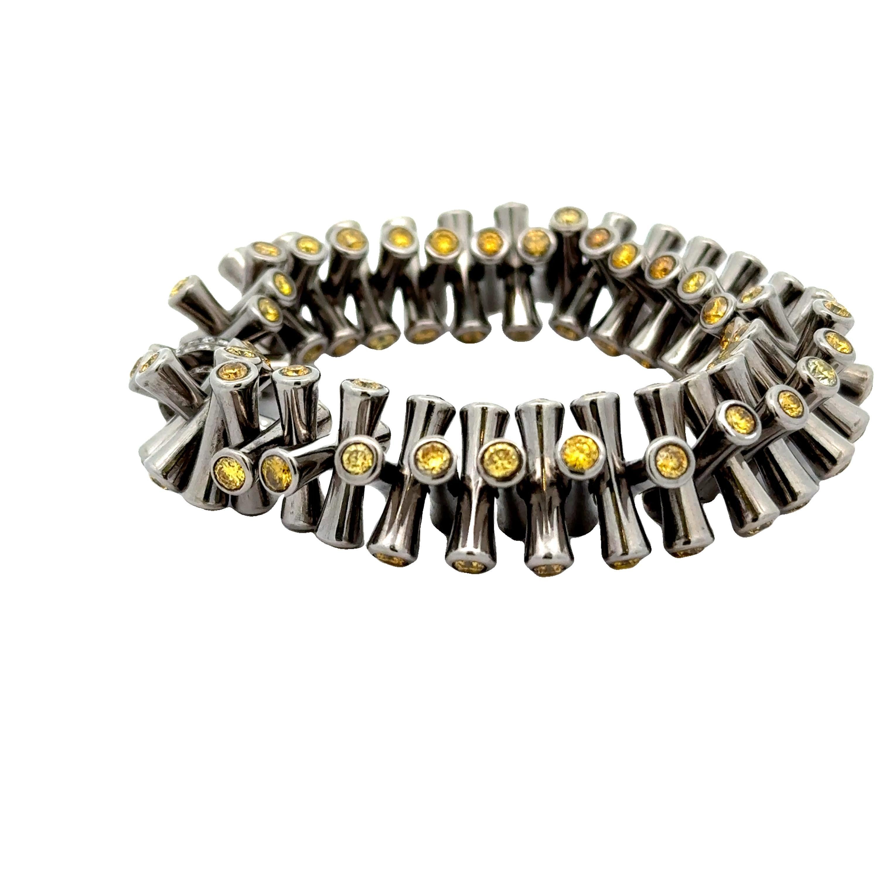 Un bracelet extensible moderne et unique en son genre, fabriqué en titane léger et élégant. Le design présente des diamants jaunes ronds, totalisant 9,84 carats, sertis aux extrémités de chaque maillon du bracelet. Des diamants blancs ronds, d'un