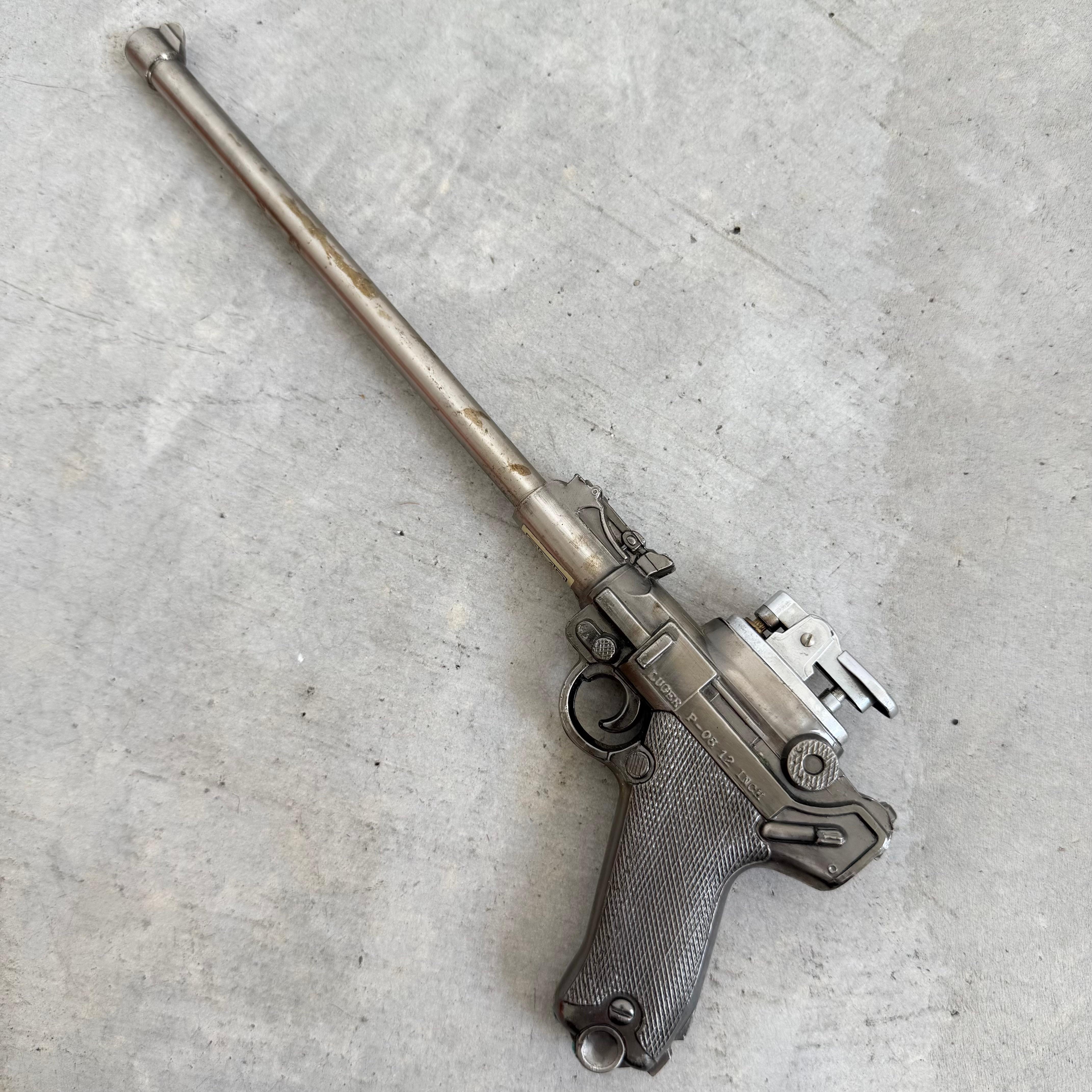 Este bonito encendedor tiene la forma de una pistola Luger de 12 pulgadas. Una pieza increíblemente rara, perfecta para cualquier coleccionista de parafernalia de fumador aficionado a las armas de fuego o a la historia. Las letras en relieve del