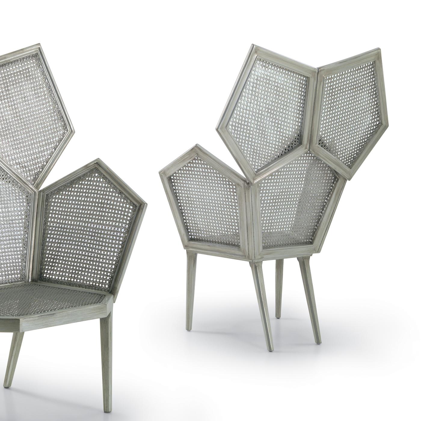 This stunning armchair is part of a series by Philippe Bestenheider that features a modular chair silhouette crafted of pentagonal elements. The wooden structure is finished with a lead leaf and comprises tapered legs with slanted back legs that