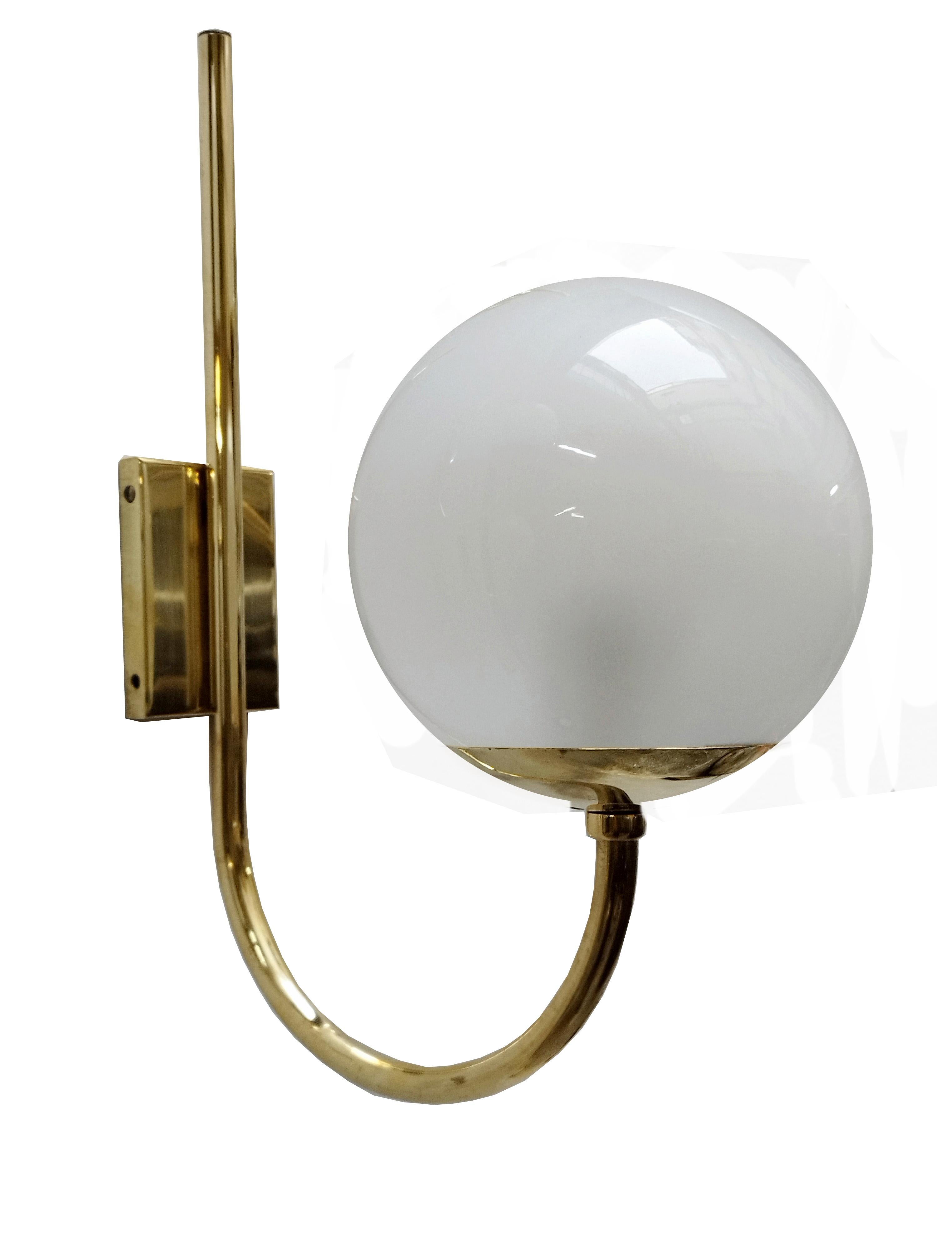 Beautiful wall lamp, design attrib. Luigi Caccia Dominioni for the Italian manufacturer Azucena.
The wall lamp has a beautiful, shining golden brass stem, which is fixed to the wall by means of a rectangular plate and which supports a white glass