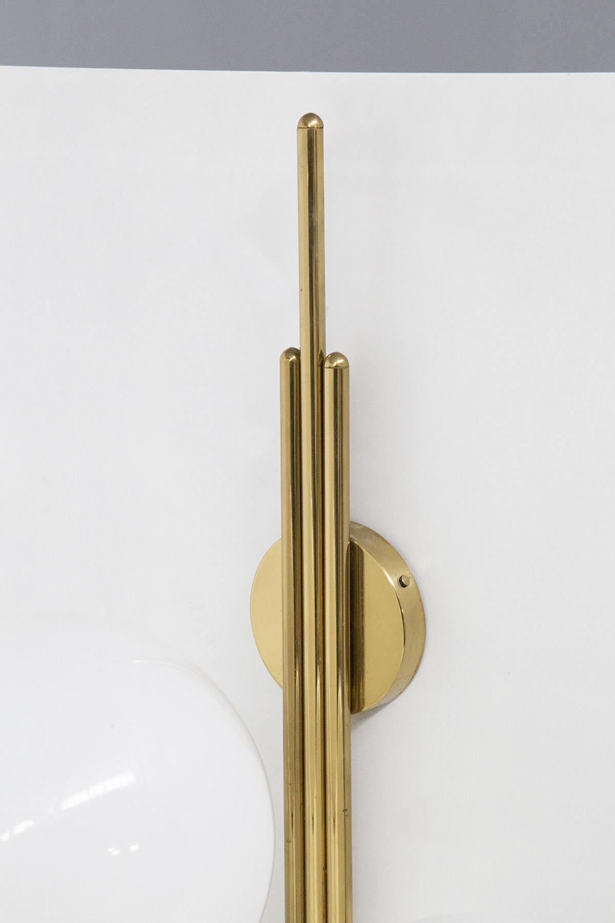 Stunning wall sconce designed by Luigi Caccia Dominioni in the 1950s for the Italian manufacturer Azucena.
The wall sconce has a stem made of beautiful, lustrous golden brass, which is fixed to the wall by means of a round plate. From this spring