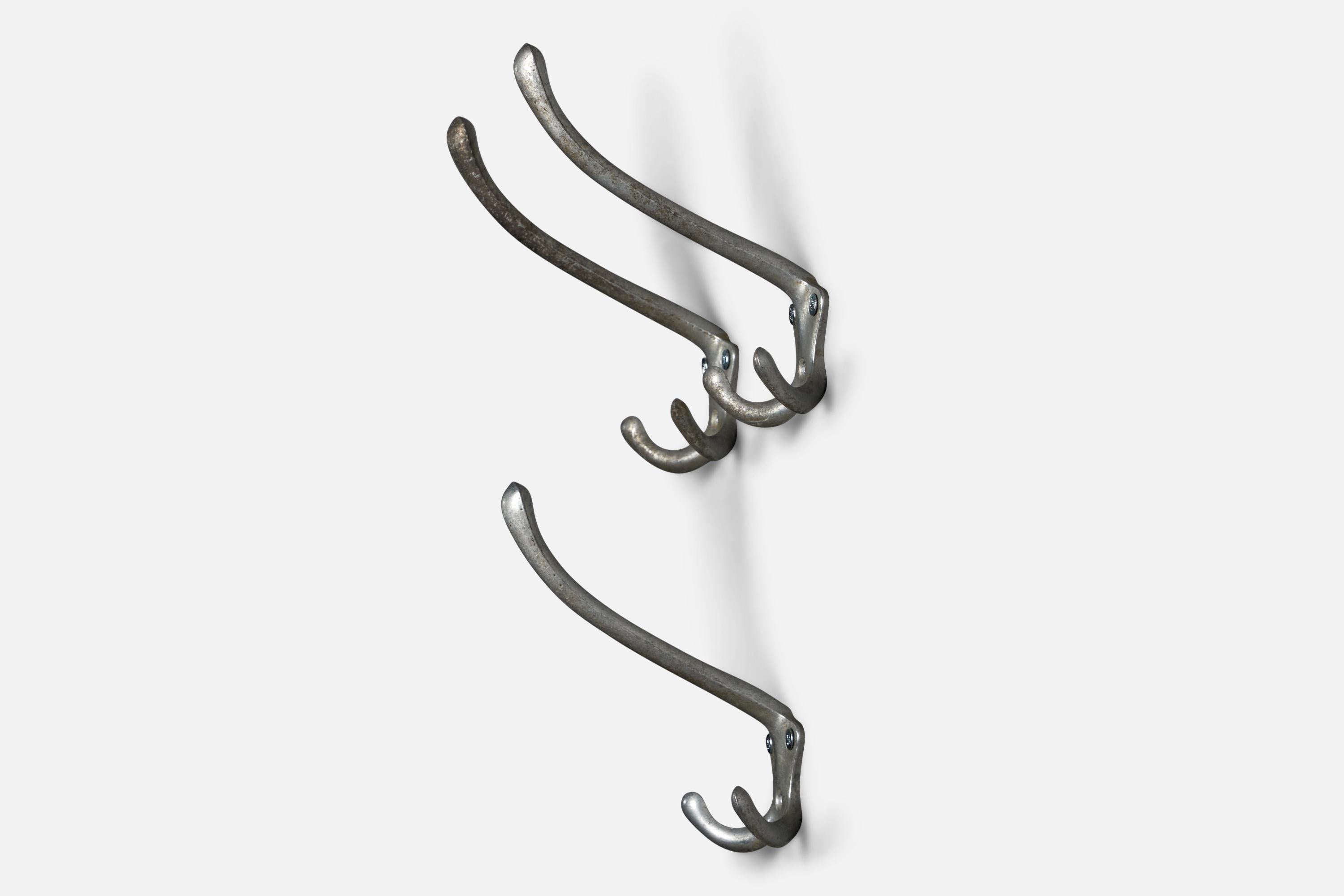 A set of three nickel coat hangers designed by Luigi Caccia Dominioni and produced by Azucena, Italy, 1950s.
