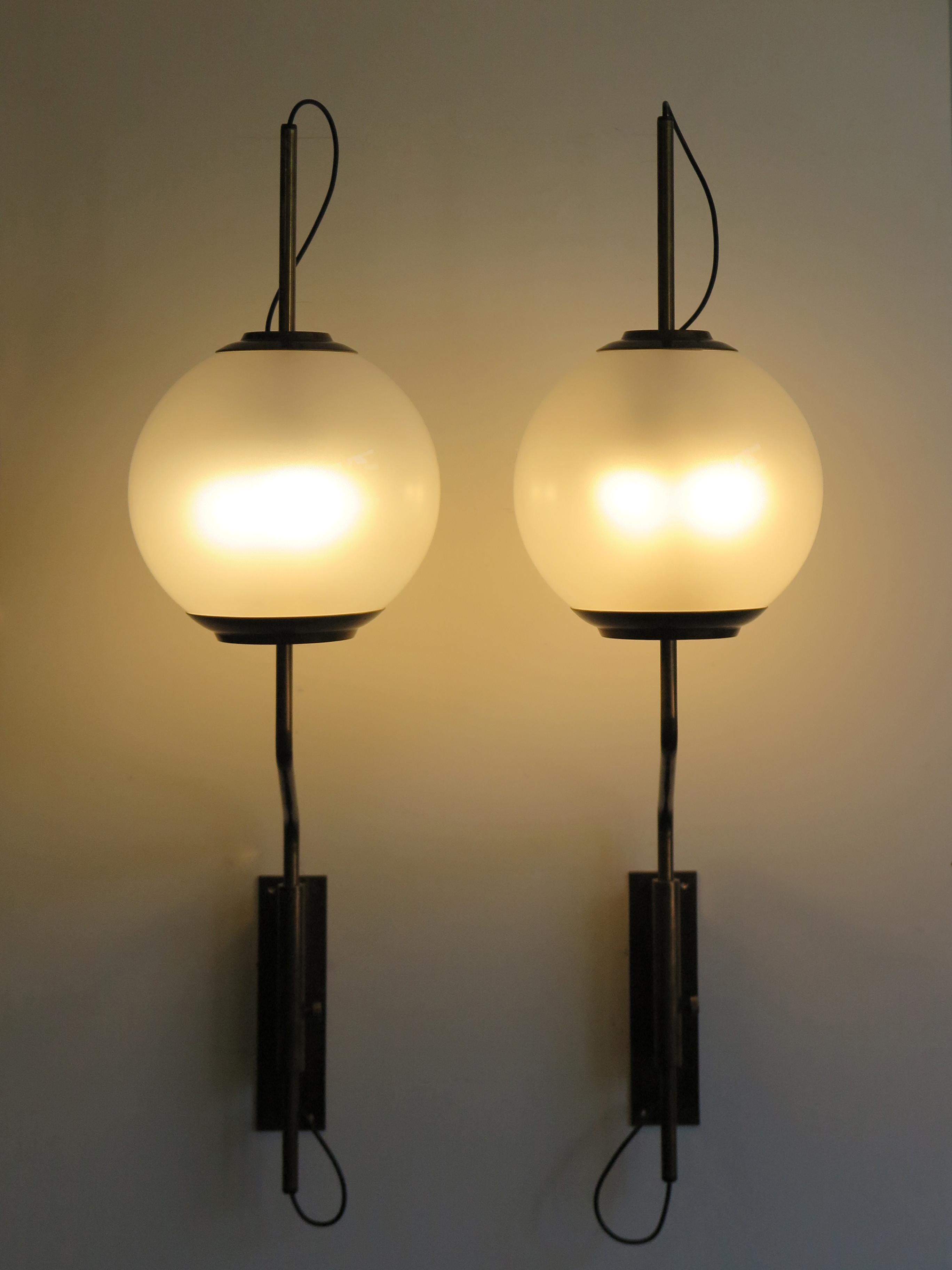 Large Italian Mid-Century Modern design height-adjustable set of two sconces wall lamps model LP11 designed by Luigi Caccia Dominioni for Azucena in 1958 with brass structure and glass spheres.
Manufacturer’s signature engraved on the brass