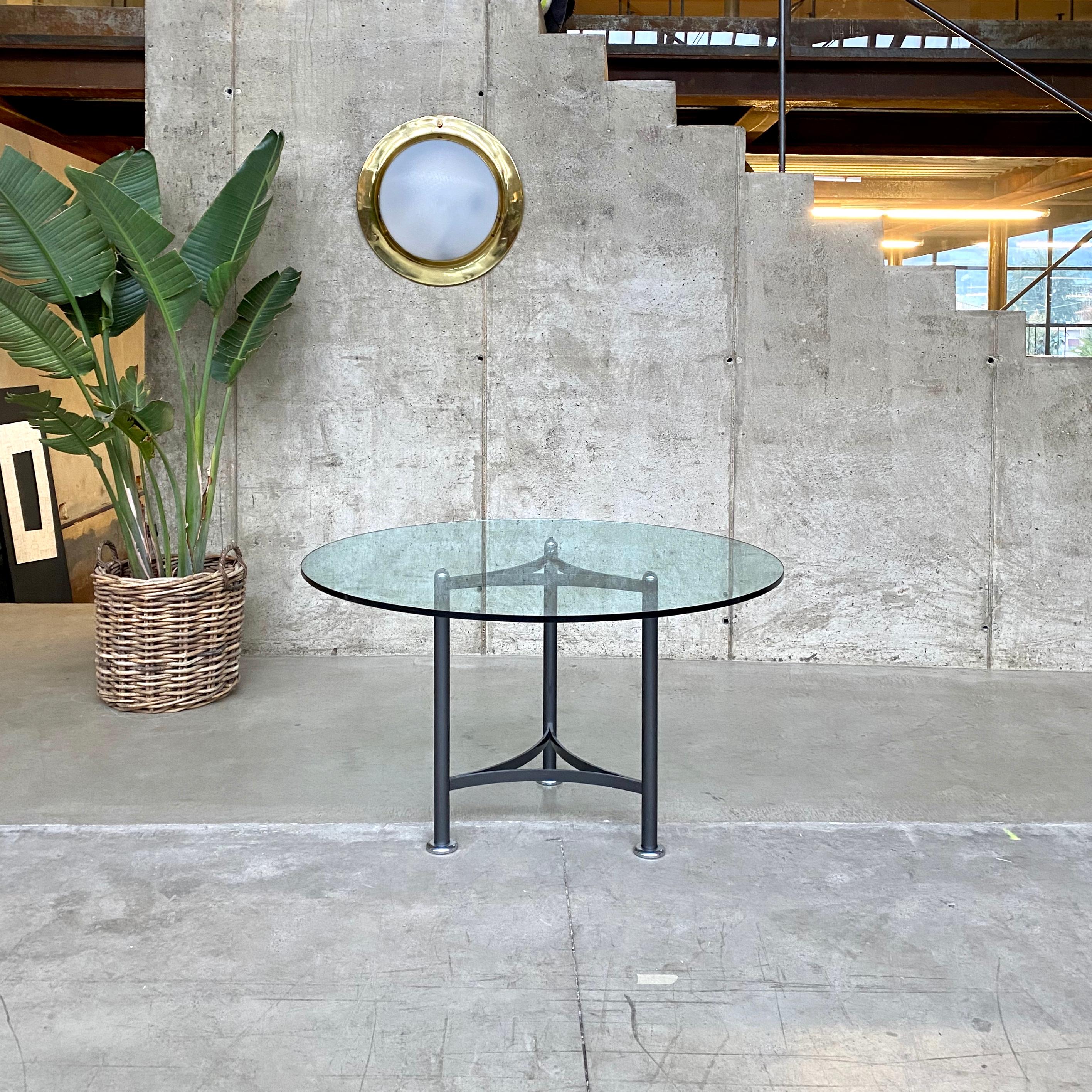 Luigi Caccia Dominioni glass round table for Azucena, 1970

Glass round top on a tubular iron tripod in a dark grey color. Every bar frame ends with the typical Dominioni style smooth feet. The chromed half-sphere as feet and top side creates a