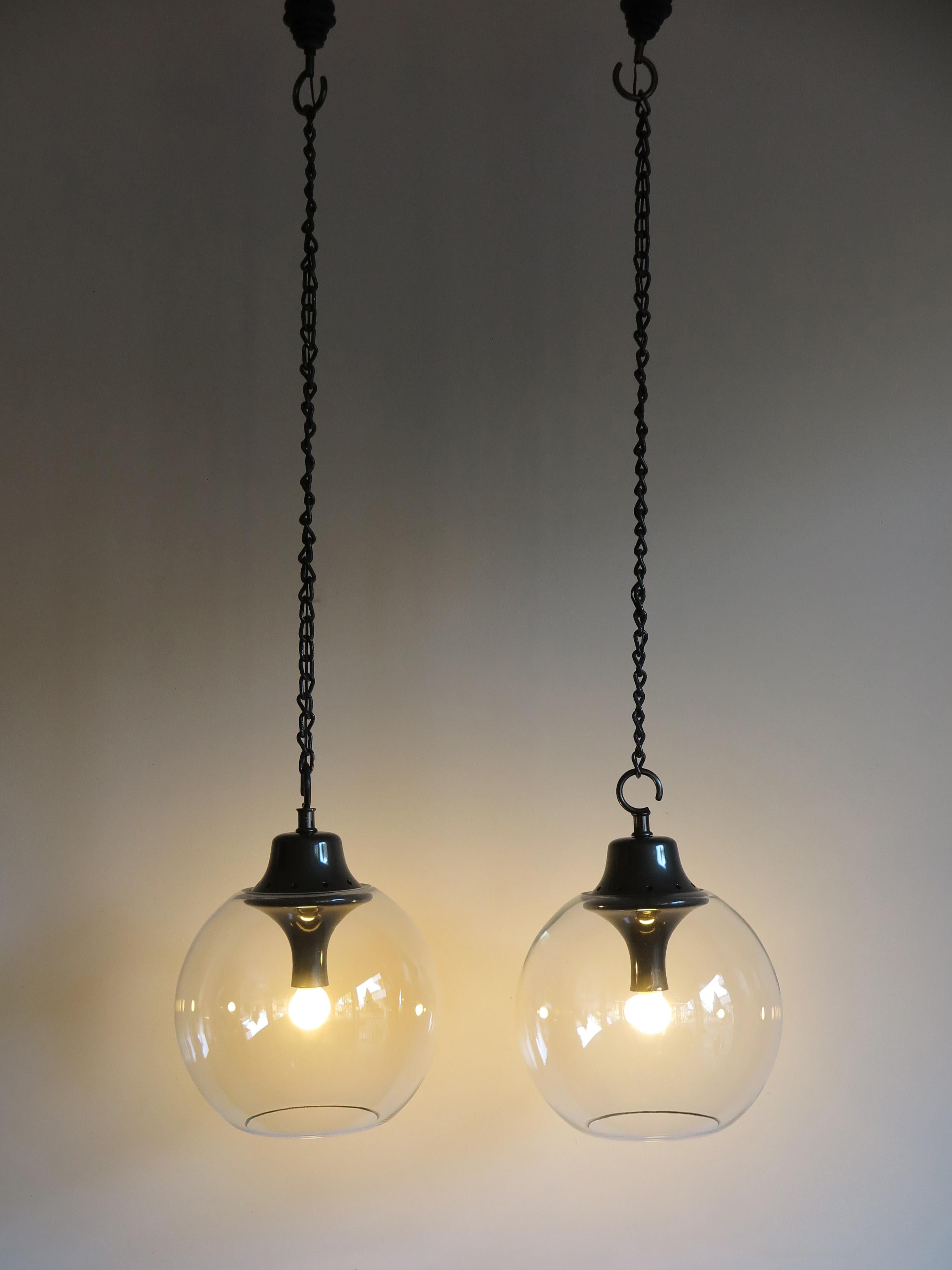 Italian Mid-Century Modern design couple of pendant lamps designed by Luigi Caccia Dominioni and produced by Azucena Milano in 1967,
lamp holder in metallized gray aluminum, double hook in burnished iron and lampshade in a globe in colorless blown