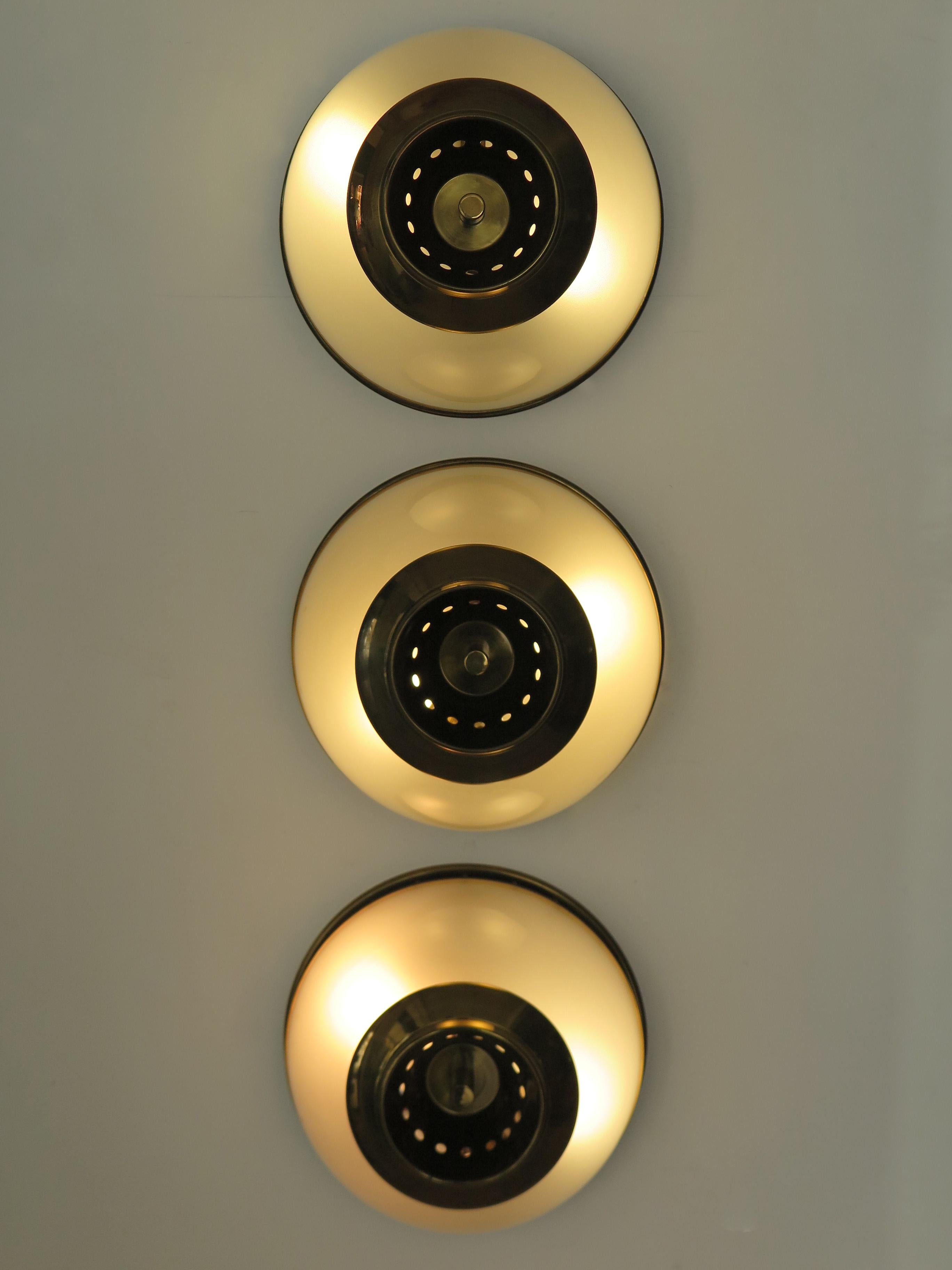 Italian midcentury modern design set of three scones wall lamps or ceiling lamps designed by Luigi Caccia Dominioni (Milan 1913 - Milan 2016 ) and produced by Azucena with brass frame and details and half globe in frosted glass internally, Italy