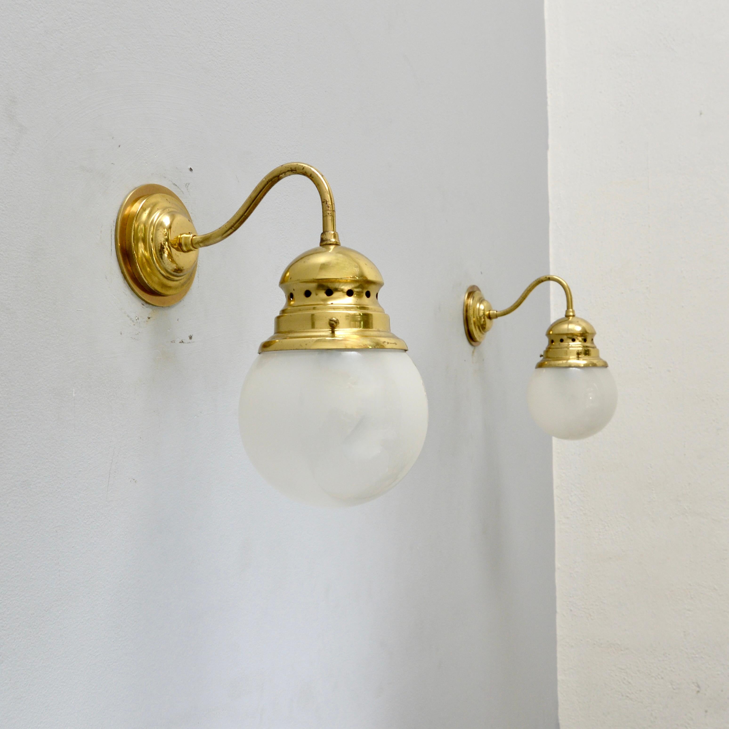 (3) Elegant Italian “Lampione” sconces from the 1950s by Luigi Caccia Dominioni. These sconces are a smaller version of the classical fixture and are in a the original aged brass finish and glass. Partially restored and rewired with (1) E26 medium