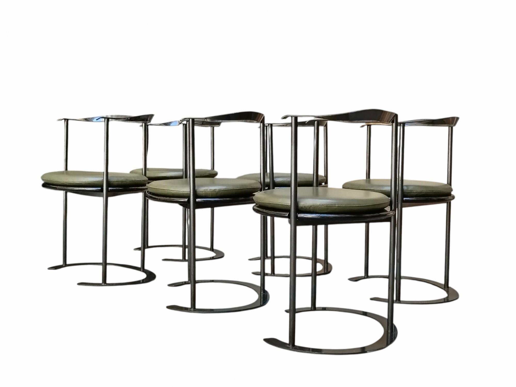 Silla Catilina con estructura de acero pintado, asiento de madera contrachapada y cojines de poliuretano tapizados y recubiertos de piel Claudio Valtorta verde. Esta icónica silla fue diseñada por Luigi Caccia Dominioni y producida por Azucena a