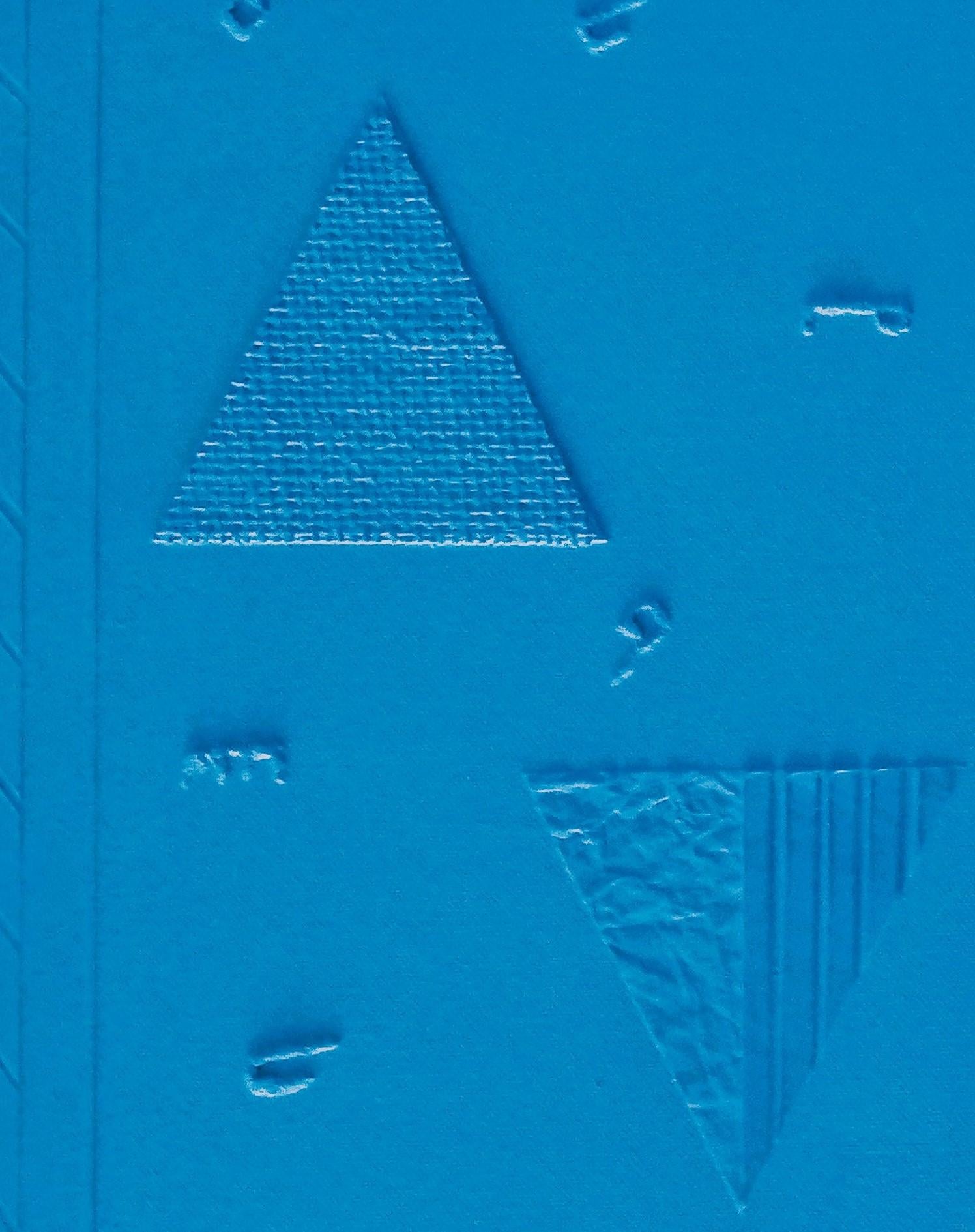 This captivating artwork is a monochromatic masterpiece in a vivid shade of blue, exploring the interplay of geometry and texture. The piece is divided into two panels, each adorned with embossed triangular shapes, subtly varied in orientation and