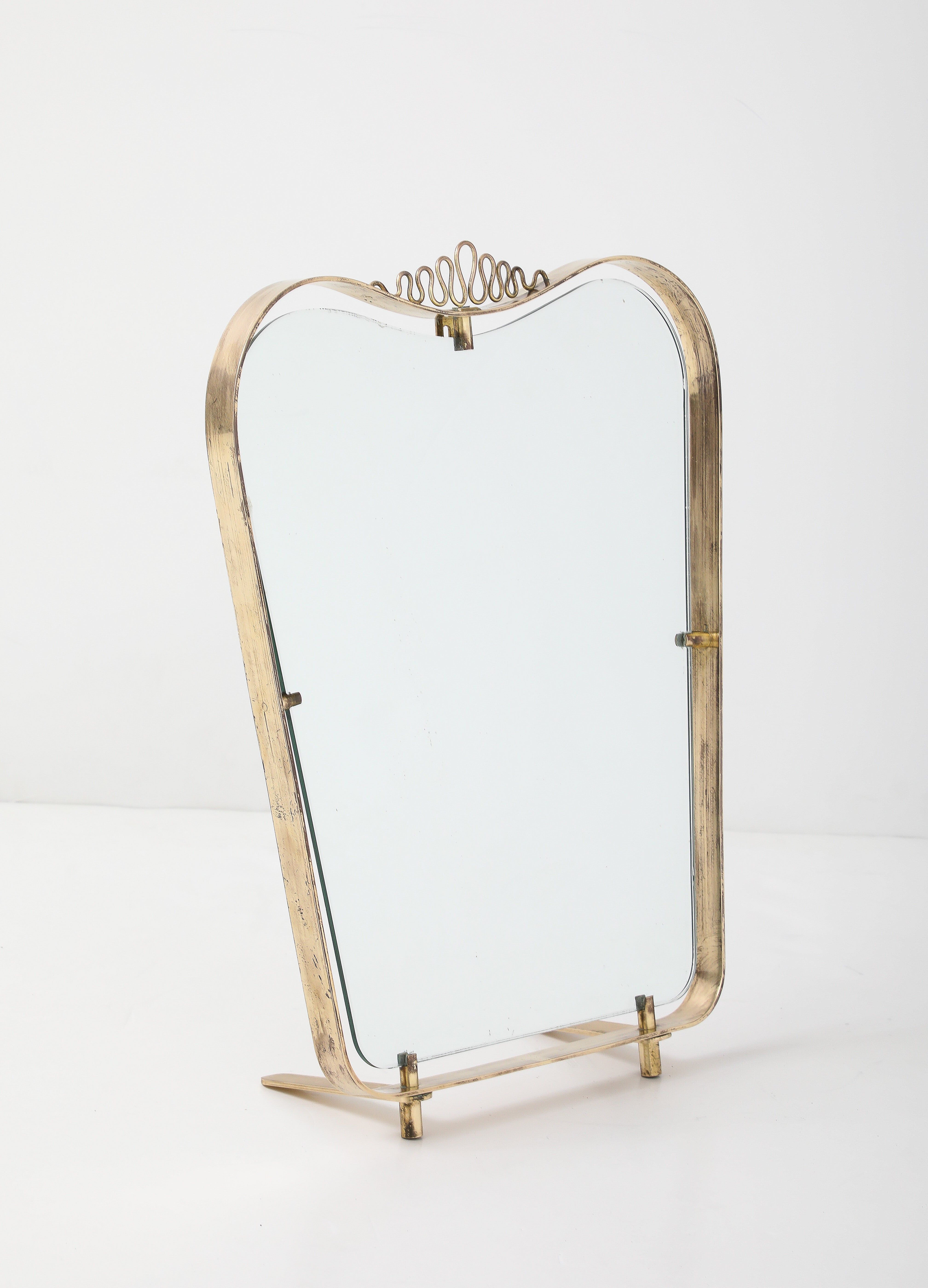 Miroir de toilette en laiton conçu par Luigi Fontana pour Fontana Arte, vers 1940.  La forme et la décoration de la crête sont charmantes. Les pieds en laiton servent de support à la table et, lorsqu'ils ne sont pas utilisés, ils s'adaptent