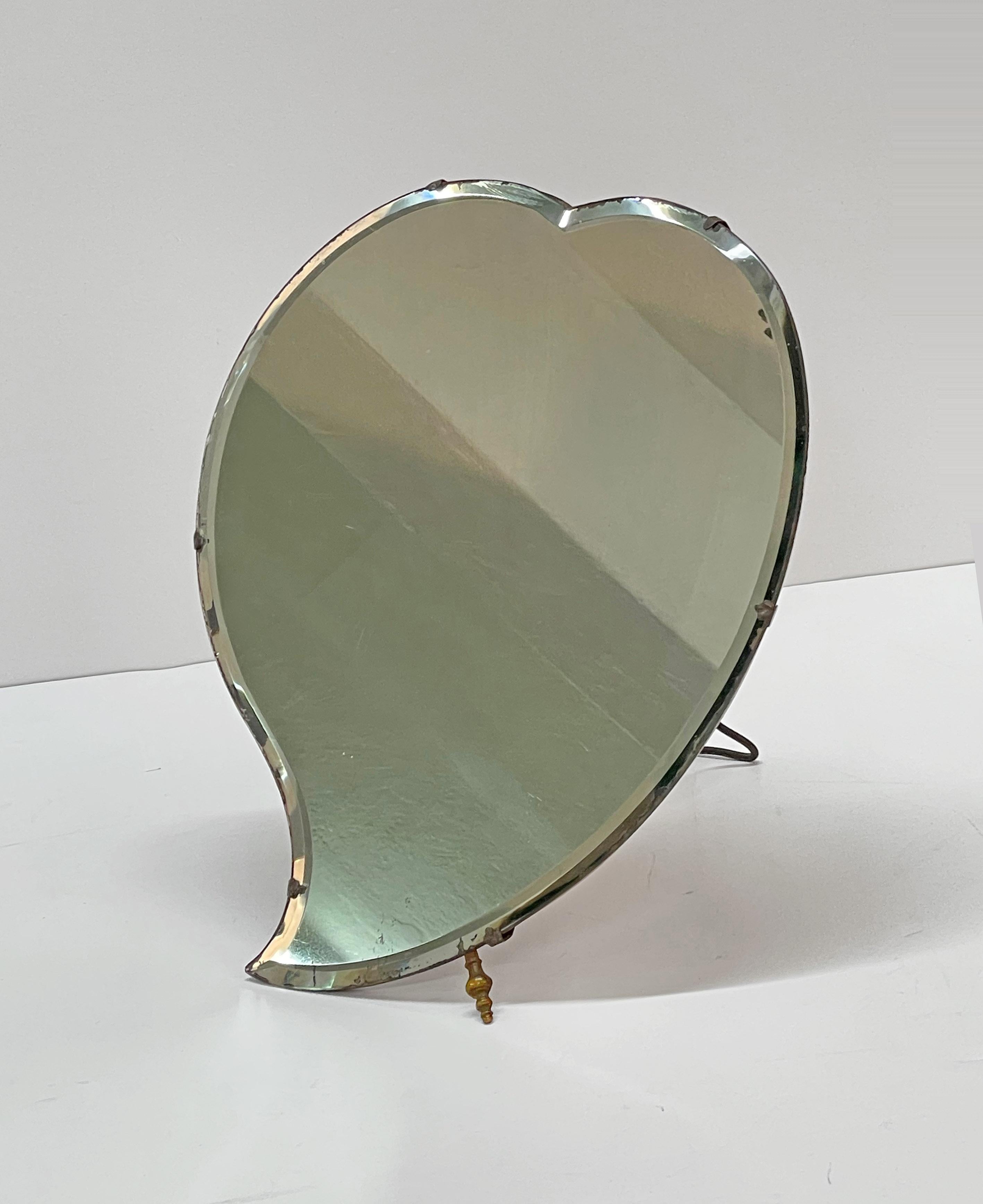 Wonderful midcentury heart-shaped table mirror. This fantastic piece was designed in Italy during the 1940s by Luigi Fontana and C.

This item is amazing as it has a lovely heart shape and solid cherry wood and iron back structure. The mirror has