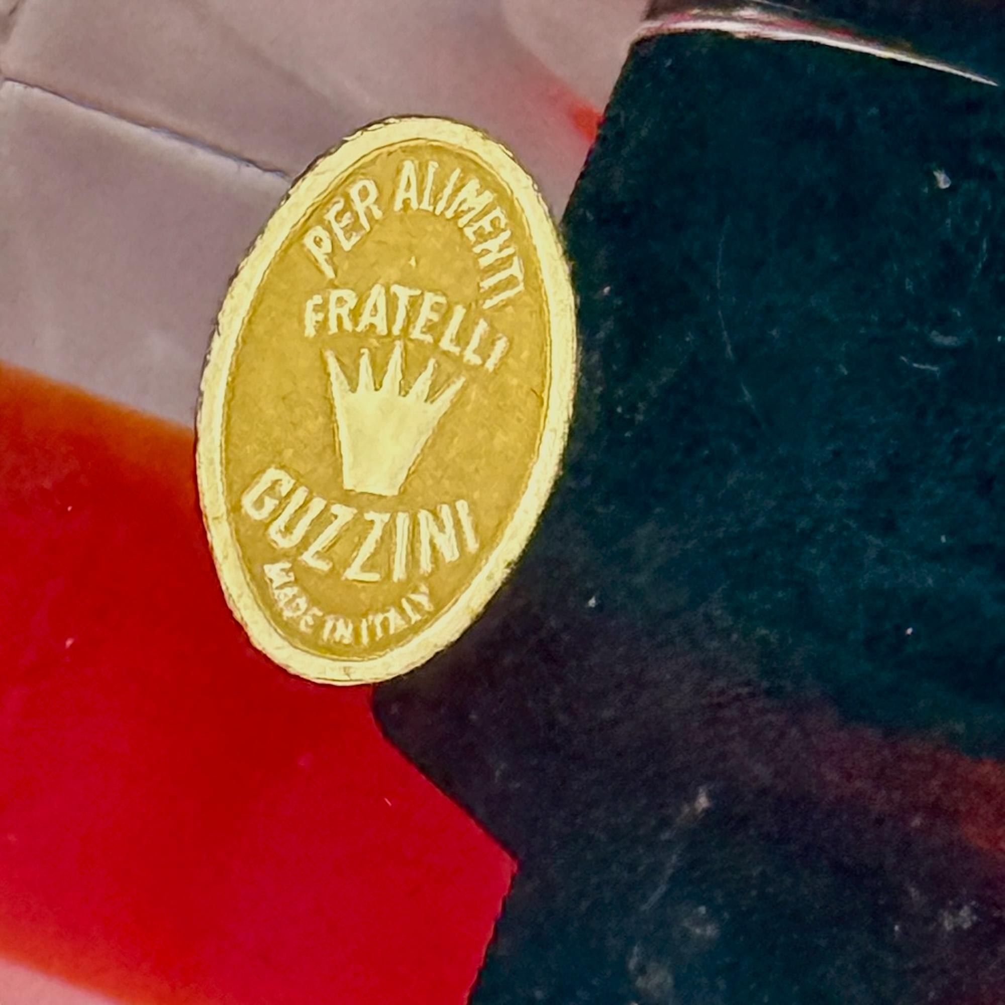 Seltener Satz von zwei Kerzenhaltern von Luigi Massoni für Fratelli Guzzini aus dem Jahr 1973.

Jedes der aus transparentem PMMA gefertigten Stücke ist mit einem auffälligen farbigen Einsatz versehen - einer in leuchtendem Rot, der andere in warmem