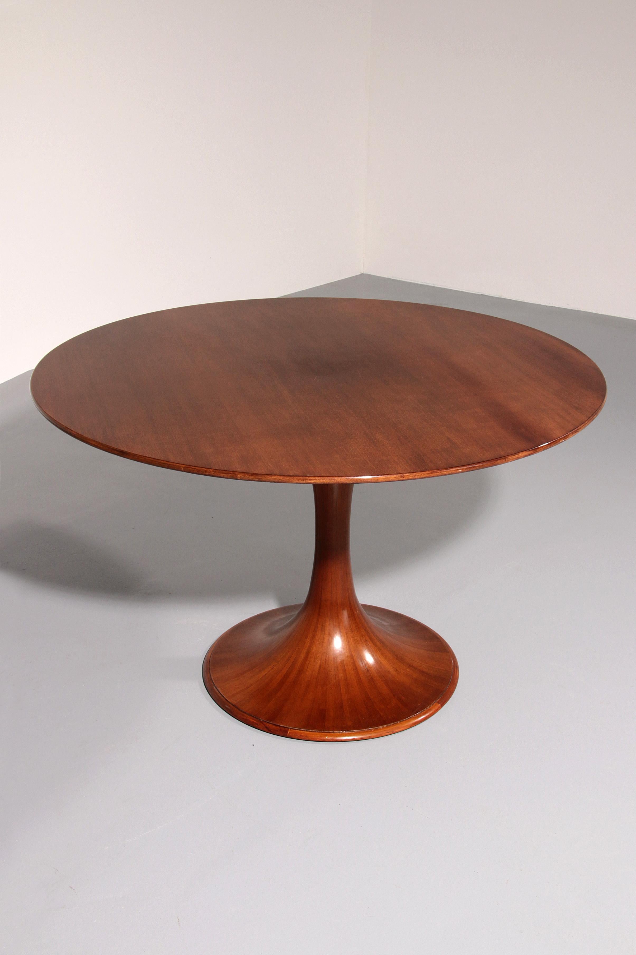 

Remarquable table de salle à manger à piédestal rond conçue par Luigi Massoni et produite par Mobilia en Italie, 1959. Cette pièce élégante présente une base sculpturale de style tulipe avec des pieds piédestaux finement détaillés mettant en