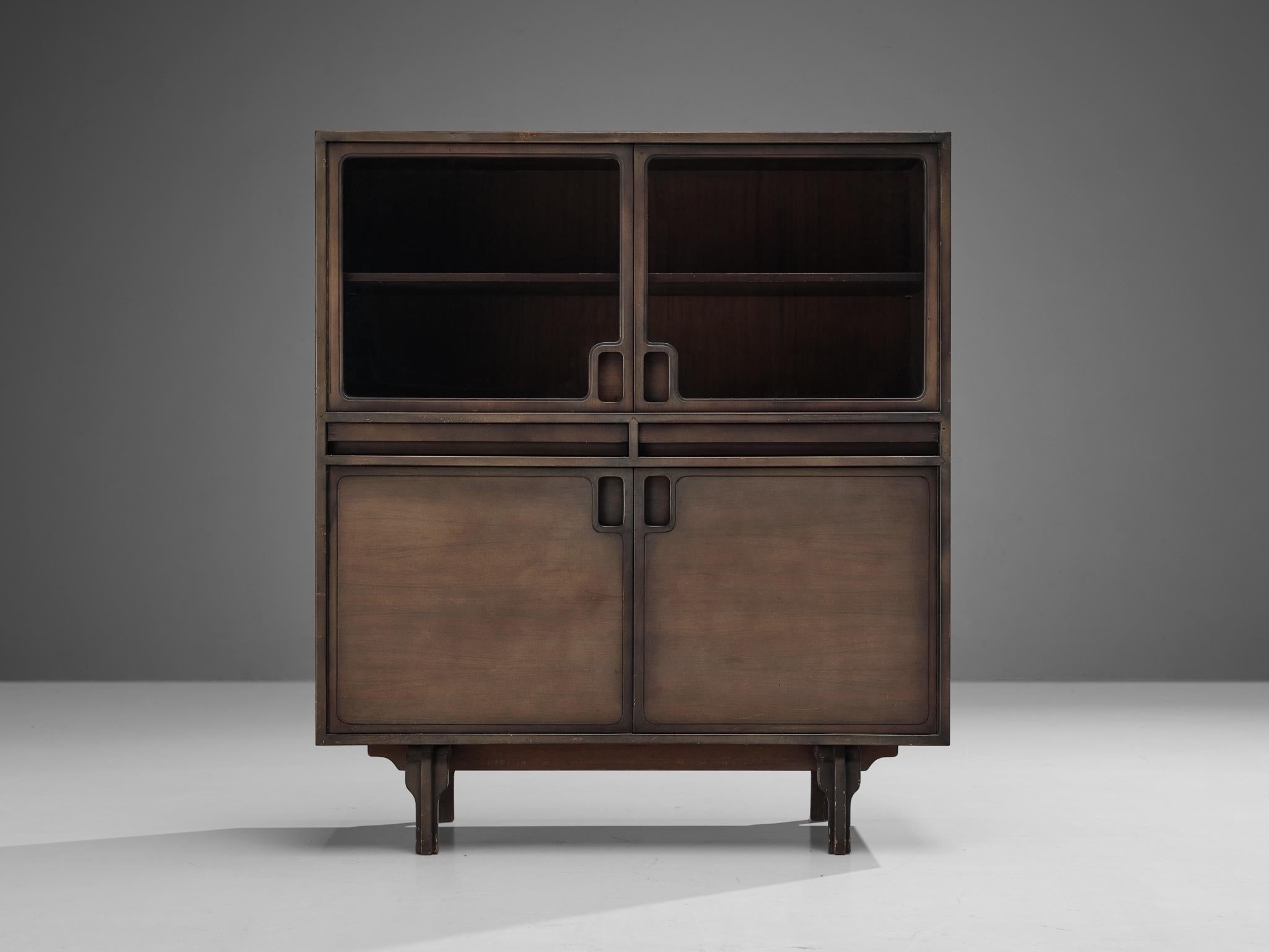 Luigi Massoni for Guzzini, wood, glass, Italy, 1960s. 

This Italian cabinet, designed by Luigi Massoni for Guzzini in the sixties, is executed in dark stained wood and glass. It consists of two wooden doors with characteristic black round inlayed