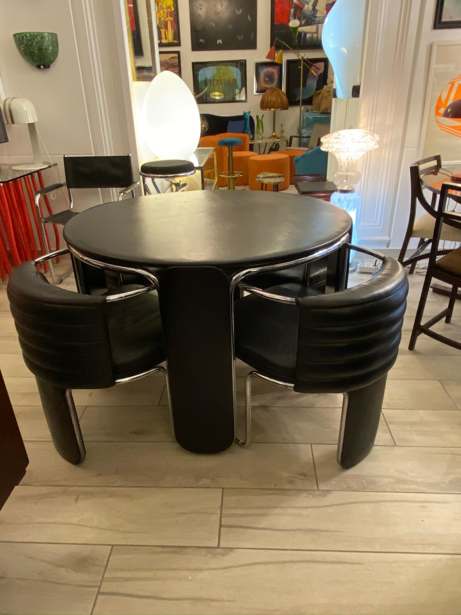Exceptional dining or game table with four armchairs made in the 1970s in black leather and chromed steel tubular.
The armchairs measure 60 x 65 x 60 cm.
Design Luigi Massoni for Poltrona Frau, signed.
Luigi Massoni Designer, born in Milan in