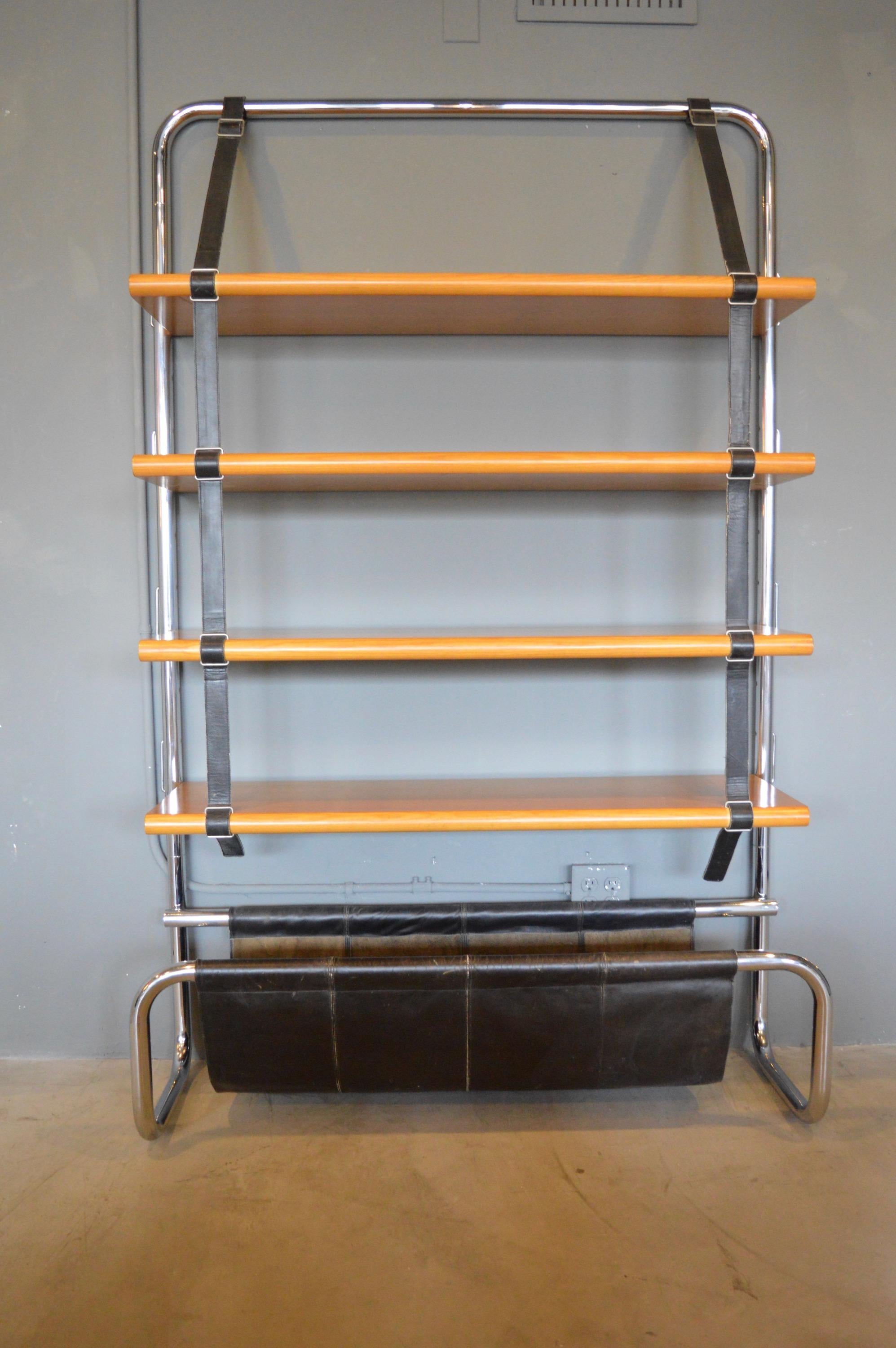 Stunning chrome, leather and wood bookshelf by Luigi Massoni for Poltrona Frau. Made in 1971, featuring tubular chrome frame, with five oak shelves, black leather straps and leather catchall at the bottom. Shelves are suspended by saddle leather