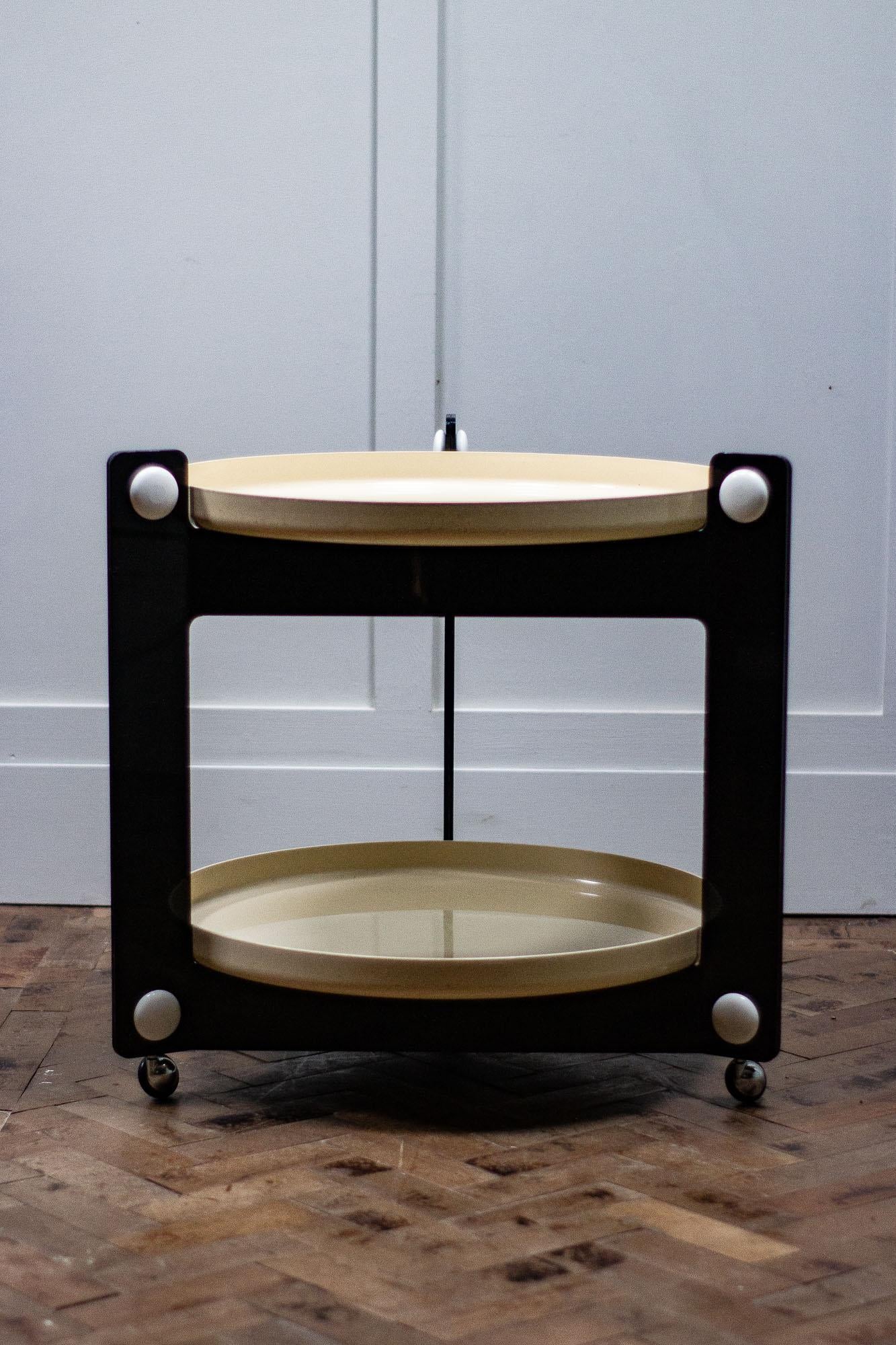 1970s Italian drinks trolley was designed by Luigi Massoni for Guzzini. 

The trolley features two trays, made of plastic. 

The two removable circular trays sit within the triangular structure.

Also in the style of Italian modern, Space Age