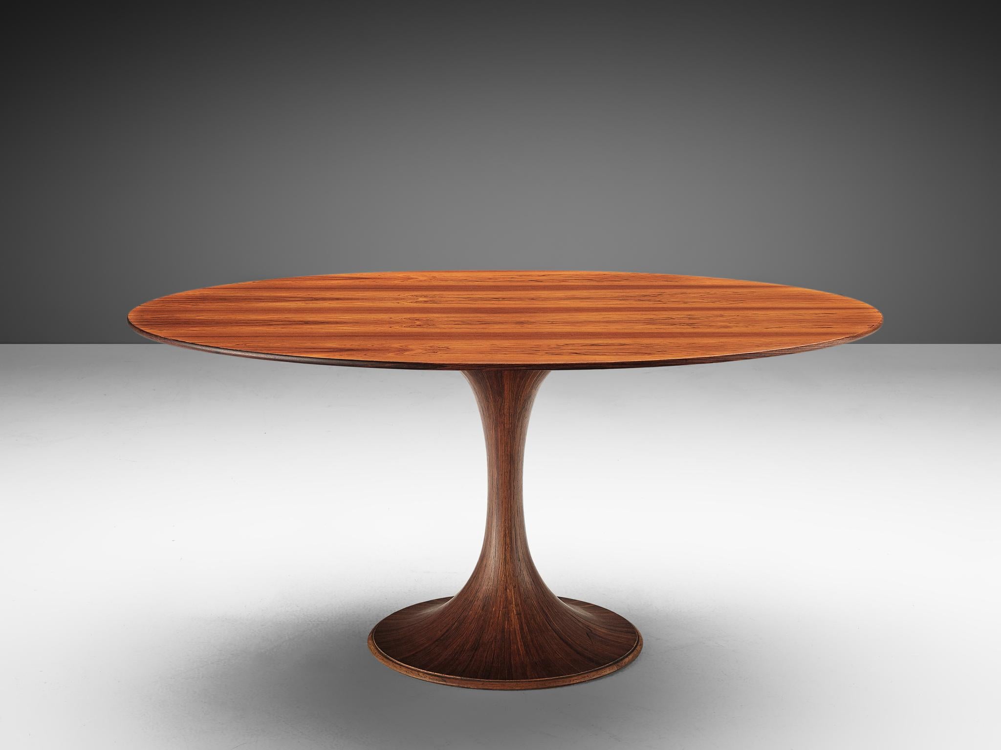 Luigi Massoni, oval dining table, rosewood, Italy, circa 1950.

This oval table features a slim, sandhour shaped foot. The pattern in this table is created by placing several plain sawn pieces in a star form. Thanks to this nifty woodwork a