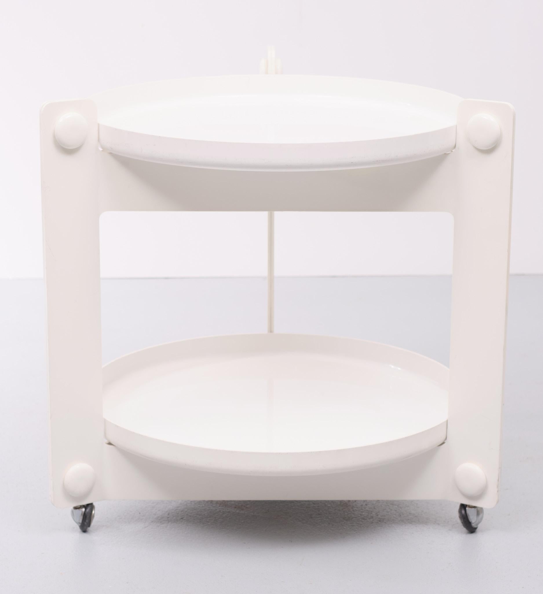 White plastic trolley This 1970s Italian serving trolley was designed by Luigi Massoni for Guzzini. The trolley features two trays, made of white plastic. The two removable circular trays sit within the triangular structures.