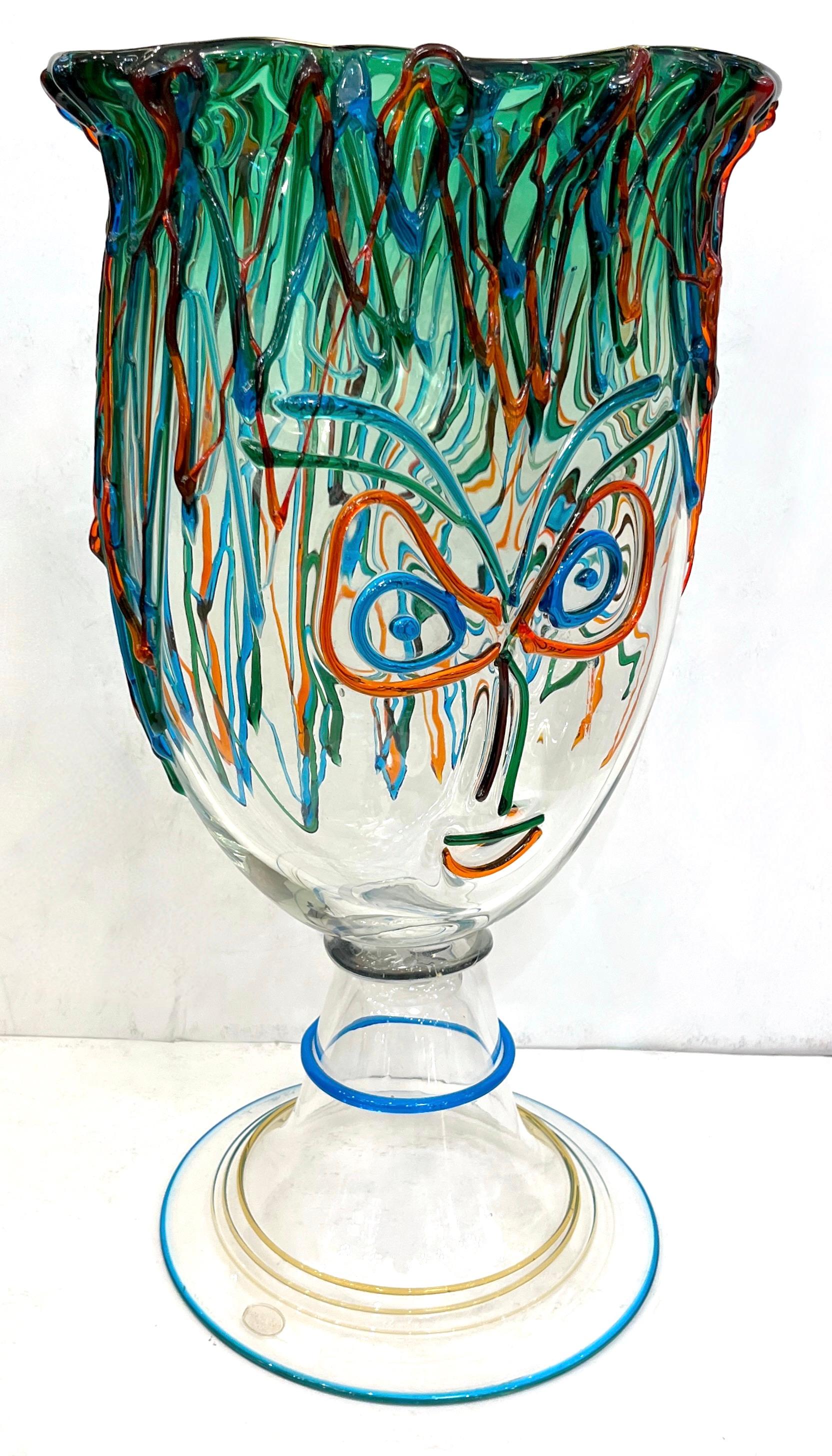 This signed vase is a unique vintage Art Glass head sculpture, of modernist dynamic design. High quality of execution with the crystal clear body tinted with a top part in gradient lime green and decorated as a Picassian face in blown Murano glass,