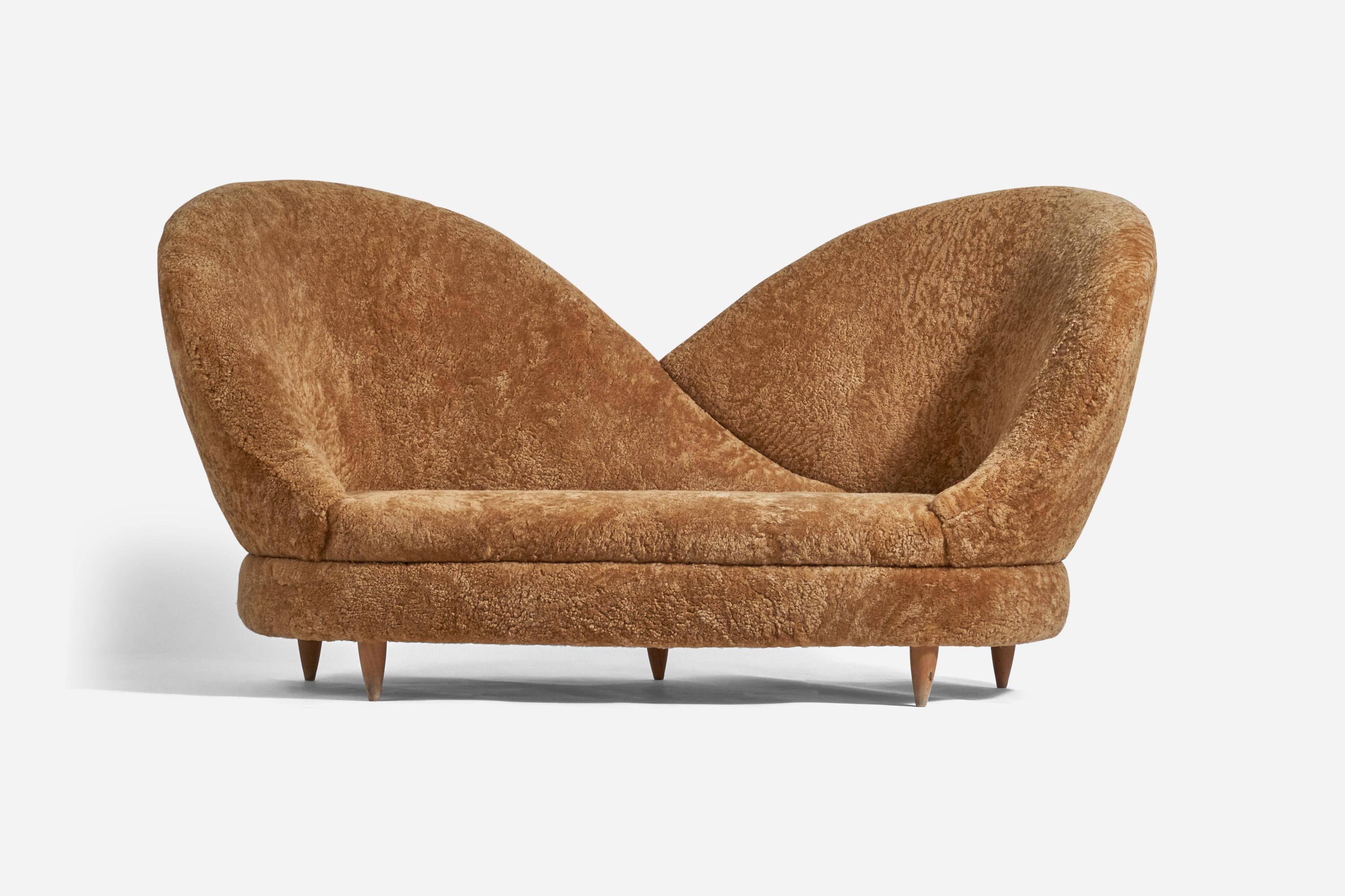 A brown sheepskin and wooden sofa designed and produced by Luigi Rossi, Italy, 1960s.

