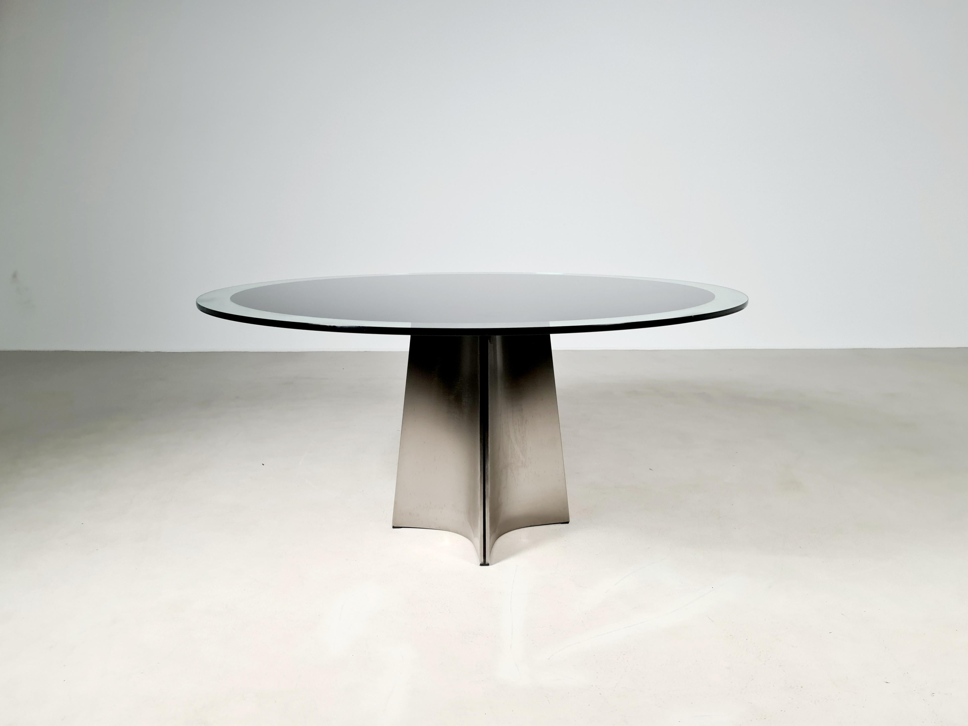 Spectacular so called 'ufo' dining table designed by Luigi Saccardo and manufactured by Arrmet, Italy 1972. The table has a stainless steel base that supports a glass top with black sticker bottom. The sticker is often very damaged and scratched