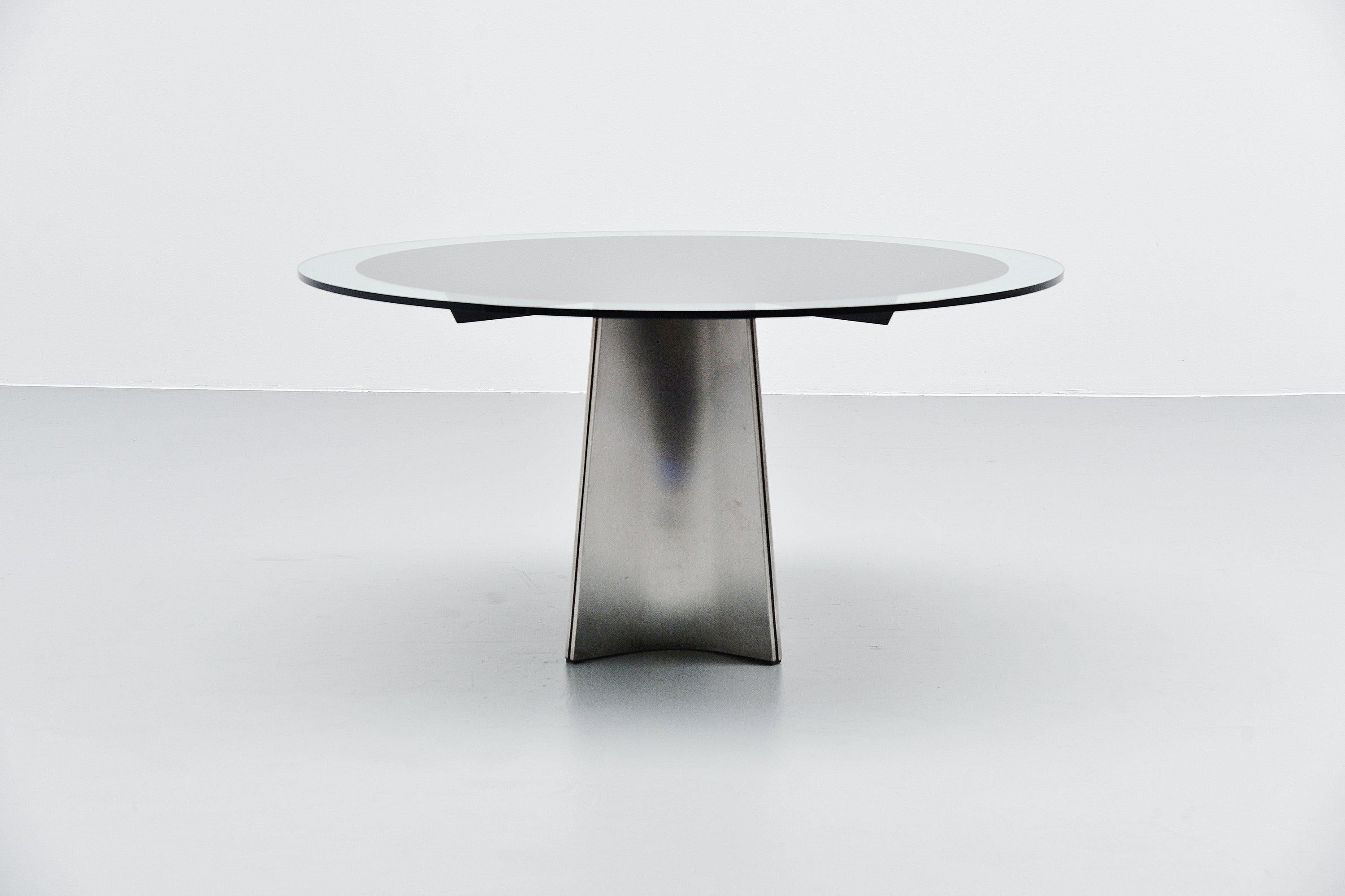 Spectacular so called 'ufo' dining table designed by Luigi Saccardo and manufactured by Arrmet, Italy 1972. The table has a stainless steel base that supports a glass top with black sticker bottom. The sticker is often very damaged and scratched