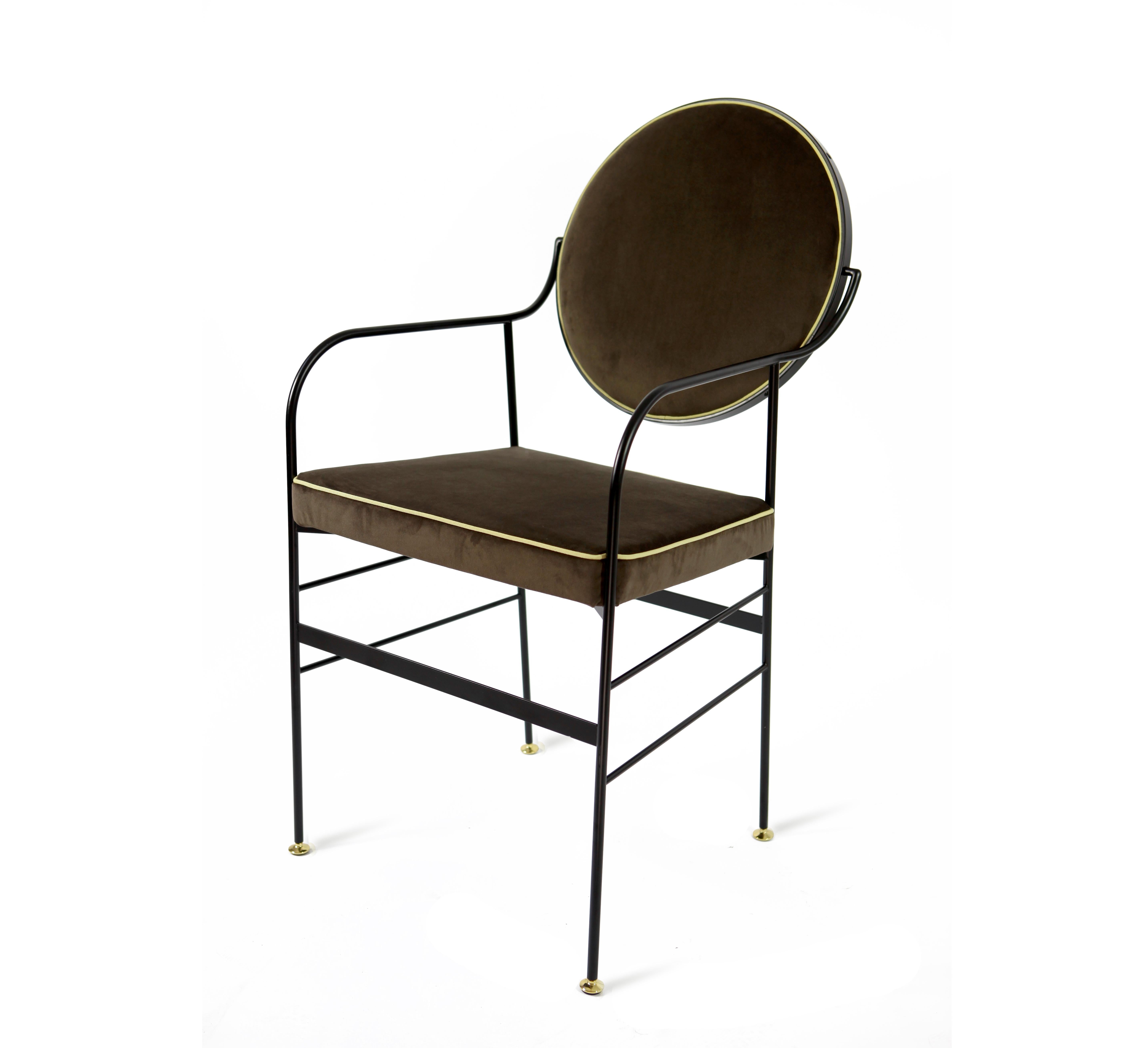 This striking chair is in iron with brass feet. The iron is dust painted and oven finished in matt black, while the back can rotate on its structure to achieve the perfect inclination. The fabric of back and seat is velvet polyester stein proof,