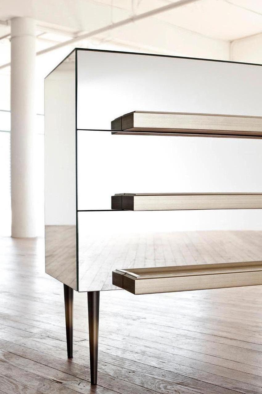 The traditional French mirror cabinet is reinterpreted leaving the mirrors frameless and exaggerating the molding to be used as the handle.
Molding is reborn as a functional handle for drawers. Placed facing a mirror, its double image hangs in