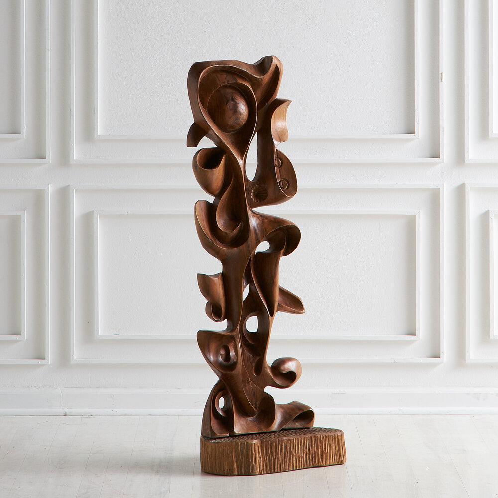A hand carved wooden sculpture by Ecuadorian artist Luis Potosi (1937 -). Artist plaque on the back.
     