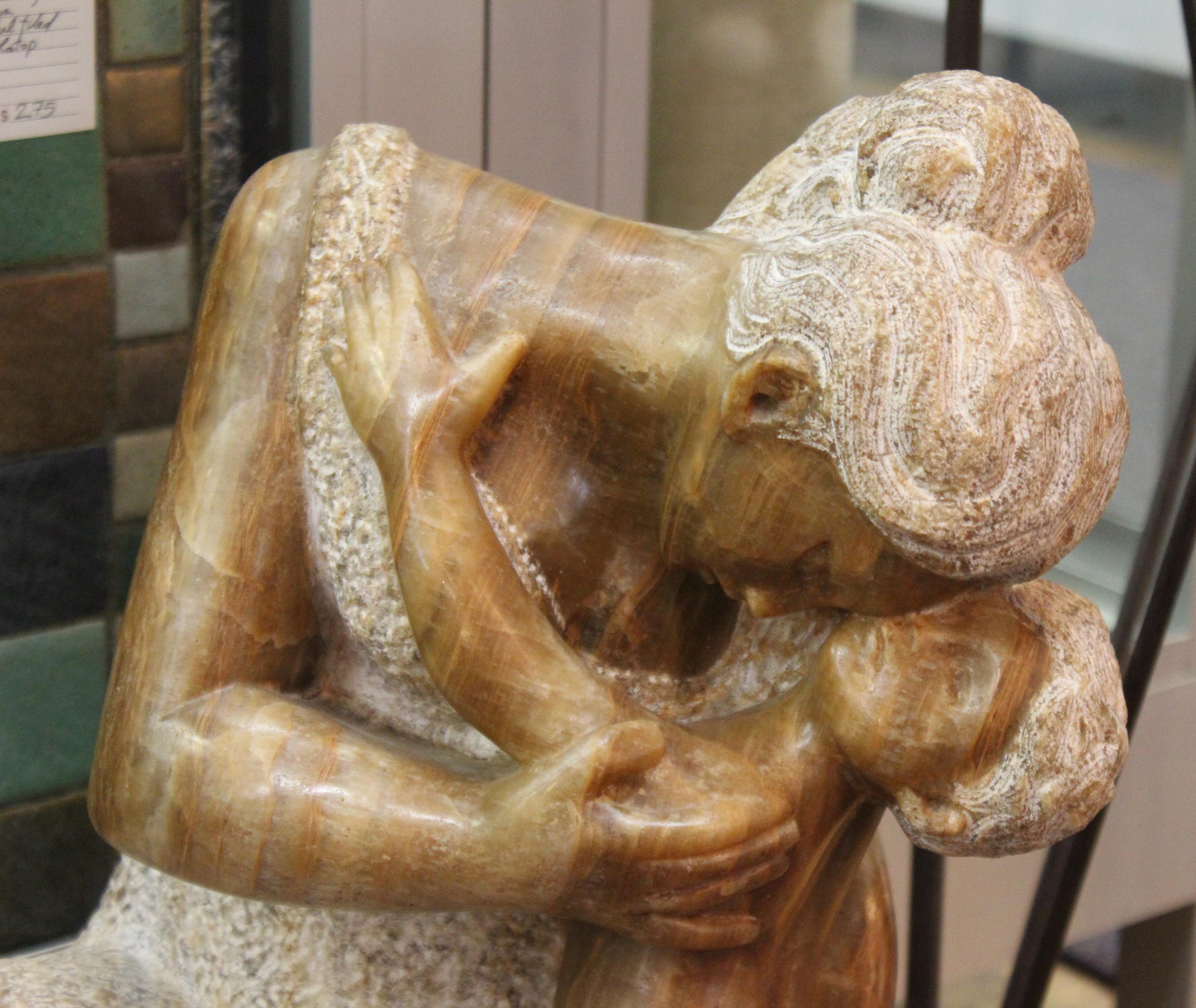 Mid-Century Modern hand carved stone sculpture of a seated mother with her young child, created by Luis Sanguino in the 20th century. The piece is signed on the base and is in great vintage condition.