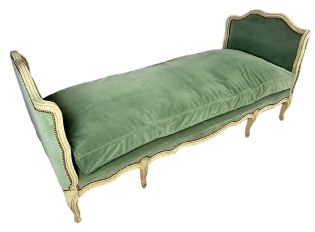 Refined French daybed bergère, Luis XV style, circa 1930, in off-white lacquered wood and upholstered in a beautiful soft green velvet with 2 roller cushions and another square.
In a very good condition with age and use. It’s an amazing piece for