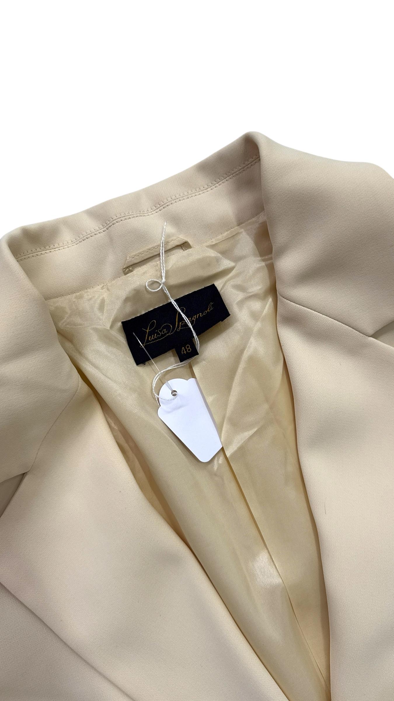 A timeless example of refined Italian tailoring, this elegant Luisa Spagnoli skirt suit in a soft ivory hue embodies classic femininity and understated sophistication. The ensemble includes a structured single-breasted blazer and a matching pencil