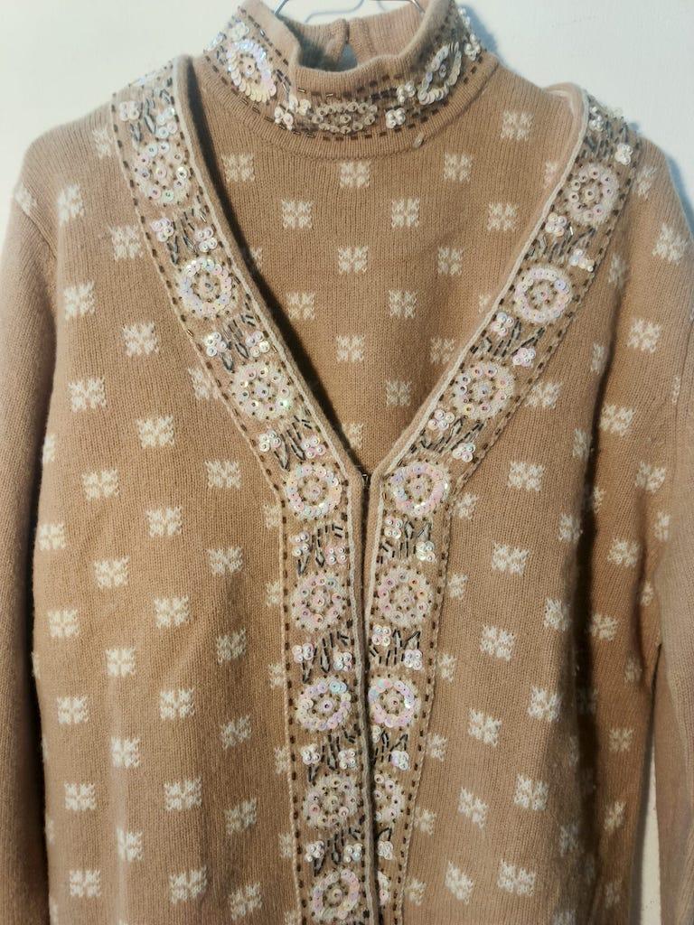 Exceptional vintage twin set by Luisa Spagnoli, crafted in Italy around 1980.
This refined ensemble includes a sleeveless high-neck top and a matching long-sleeved cardigan, both knitted in soft camel wool with delicate ivory geometric motifs. The