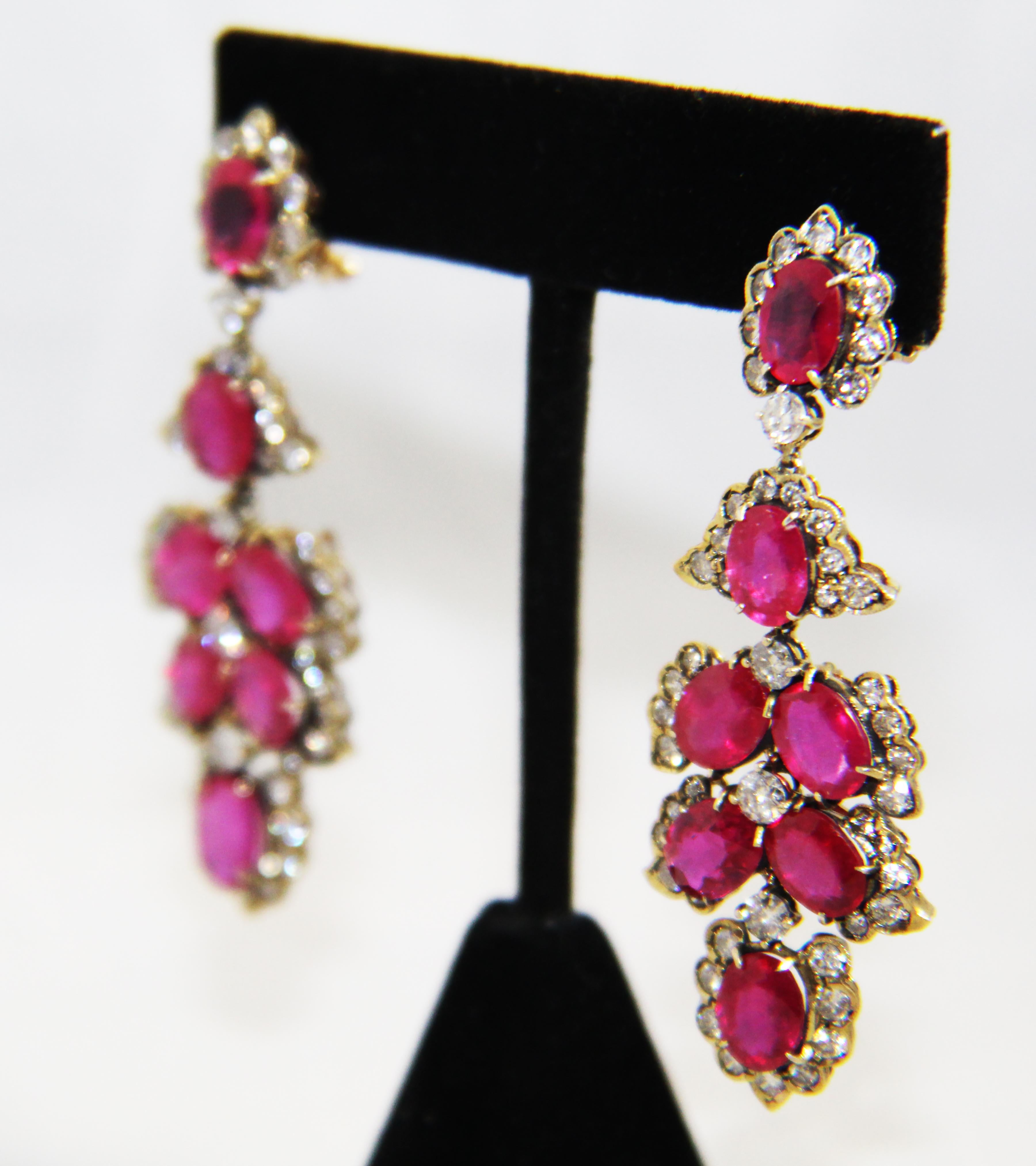 Fabricated in Italy, these stunning ruby and diamond earrings are unmistakably Luise! 14 karat yellow gold is the base that boasts 14 beautifully matched faceted oval red rubies with a combined total weight of 28.16 carats. Top level ruby is framed