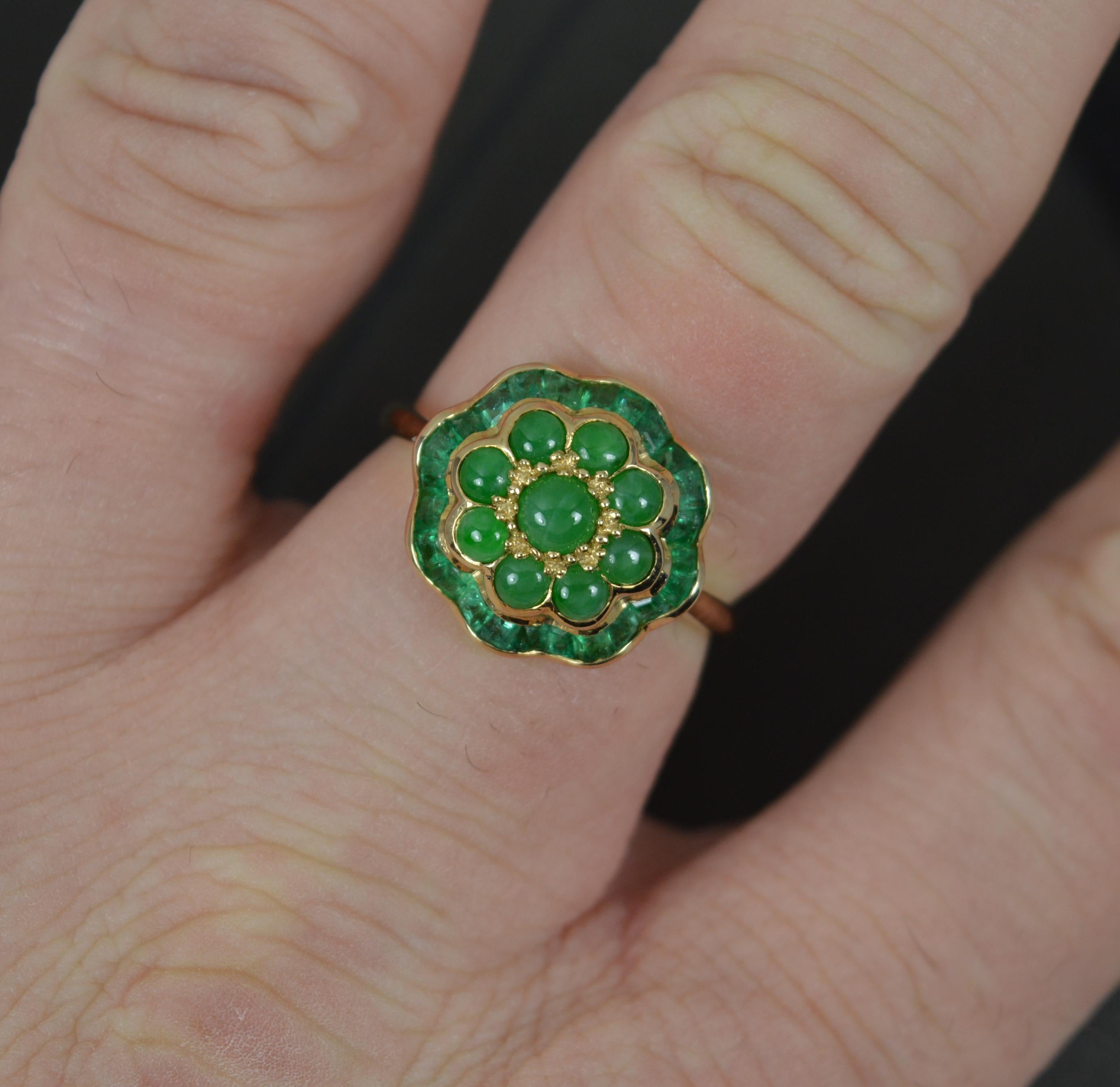 A Luke Stockley designer ring.
9 carat yellow gold example.
Designed with nine round shape green jade stones with a full border to the edge of many tapered cut green emeralds. All natural stones. 
14.5mm x 13.7mm cluster.

Condition ; Very good.