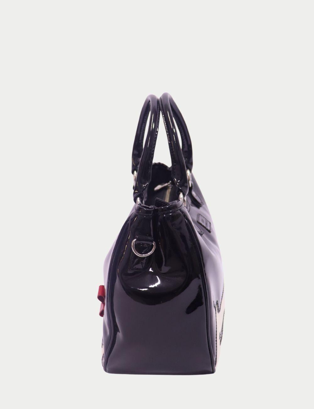 Lulu Guinness - Fourre-tout noir à motif de visage verni avec nœud rouge

Ajoutez une dose de chic ludique à votre look avec ce fourre-tout à motif de visage Lulu Guinness, dont le design audacieux et excentrique est immédiatement reconnaissable.