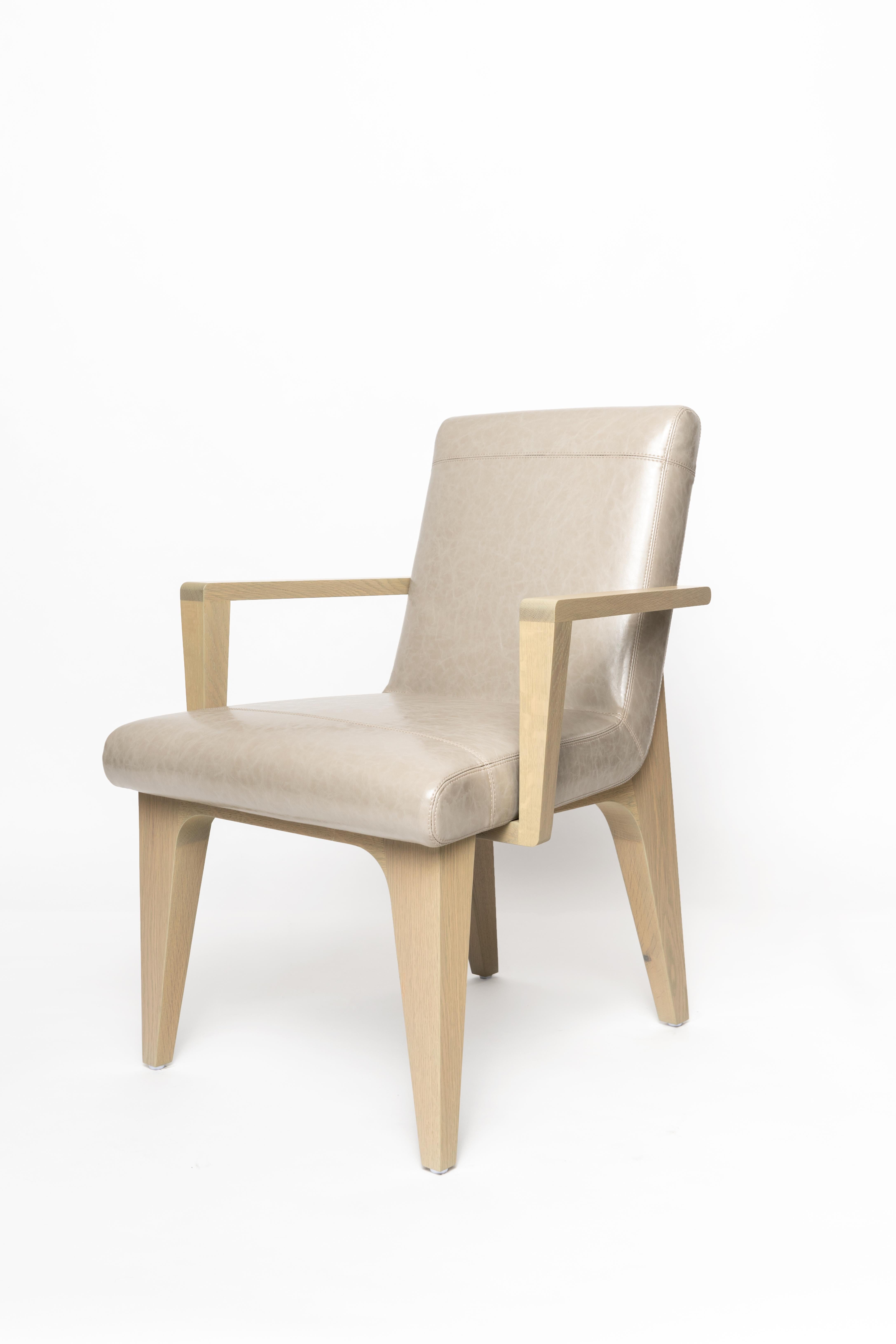 The LUMA design workshop Silo armchair is the result of thoughtful design and expert craftsmanship. LUMA tan faux leather, stone oak, and nickel, come together elegantly to create a comfortable, modern dining chair. The metal detailing and unique