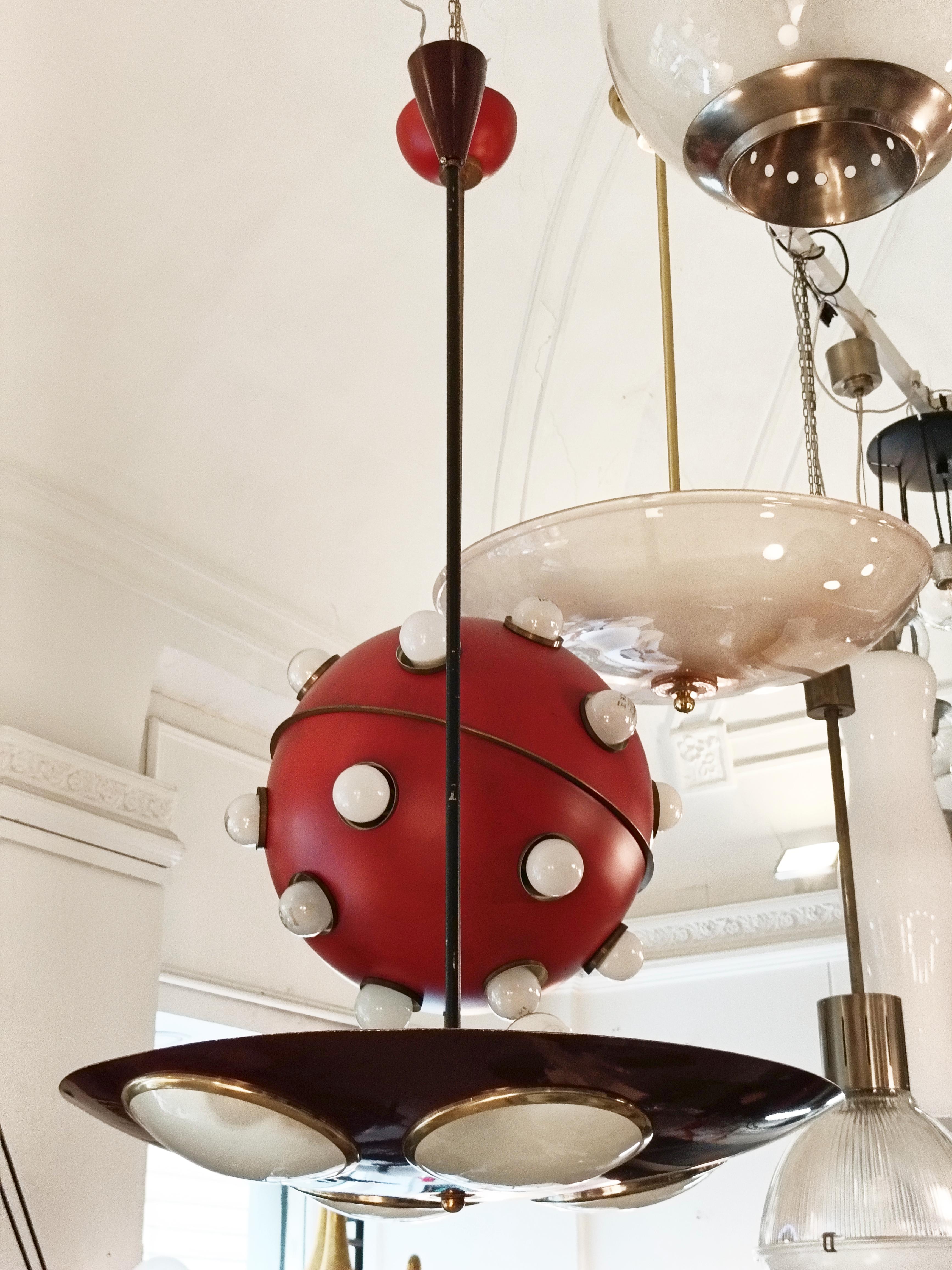 Bellissima  lámpara de suspensión italiana de Lumen Milano, fabricada en cuero y metal esmaltado de color rojo; el paralelepípedo circular de suspensión está reforzado con 4 difusores de vidrio  bordati in ottone.