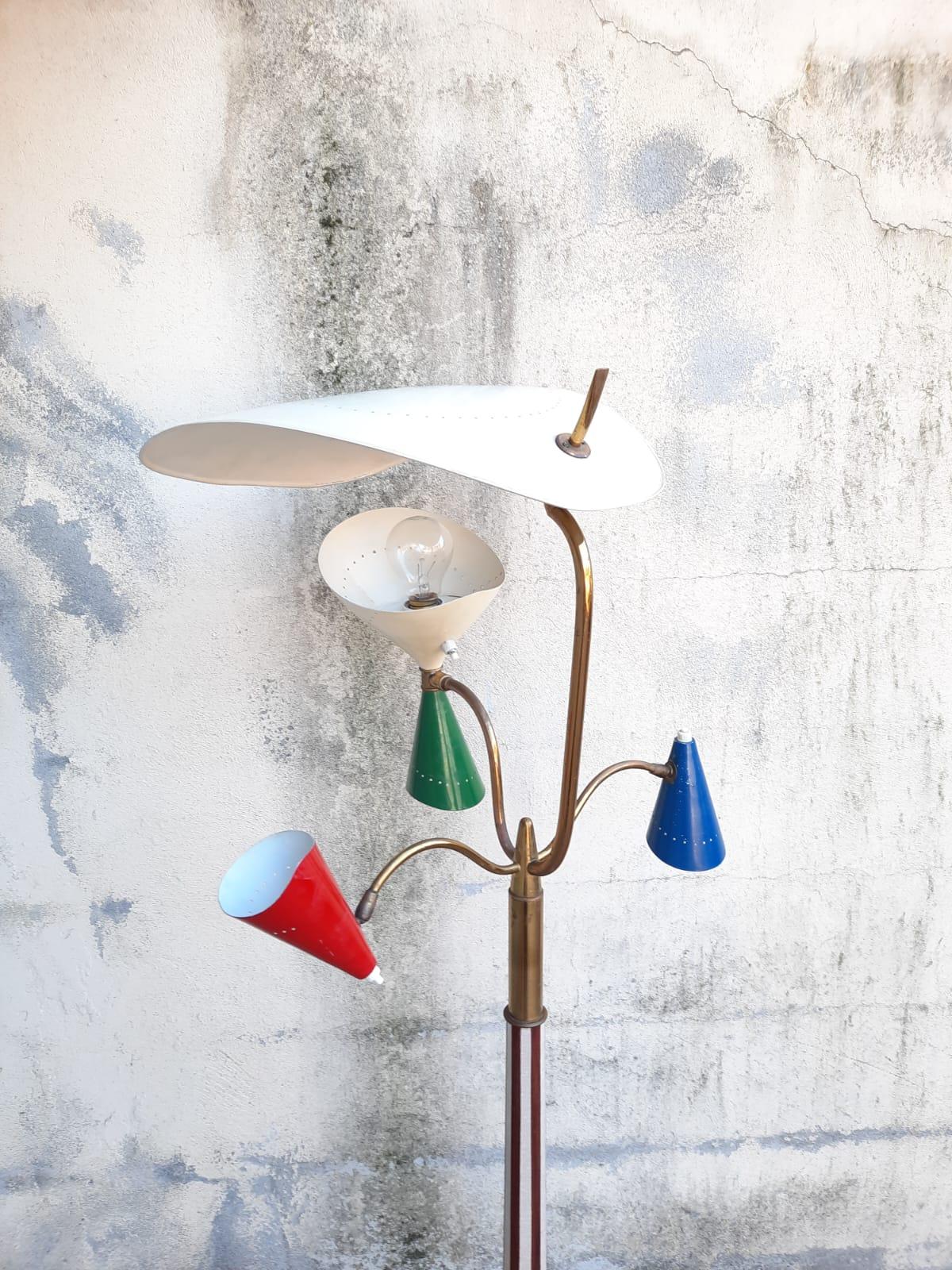 Muy elegante  lámpara de pie de los años 50 con cuatro luces regulables, conos de aluminio esmaltado, detalles de latón, varilla y base revestidas de fórmica. Obsérvese el diseño, que sigue siendo relevante a pesar de tener 70 años.
Nueva