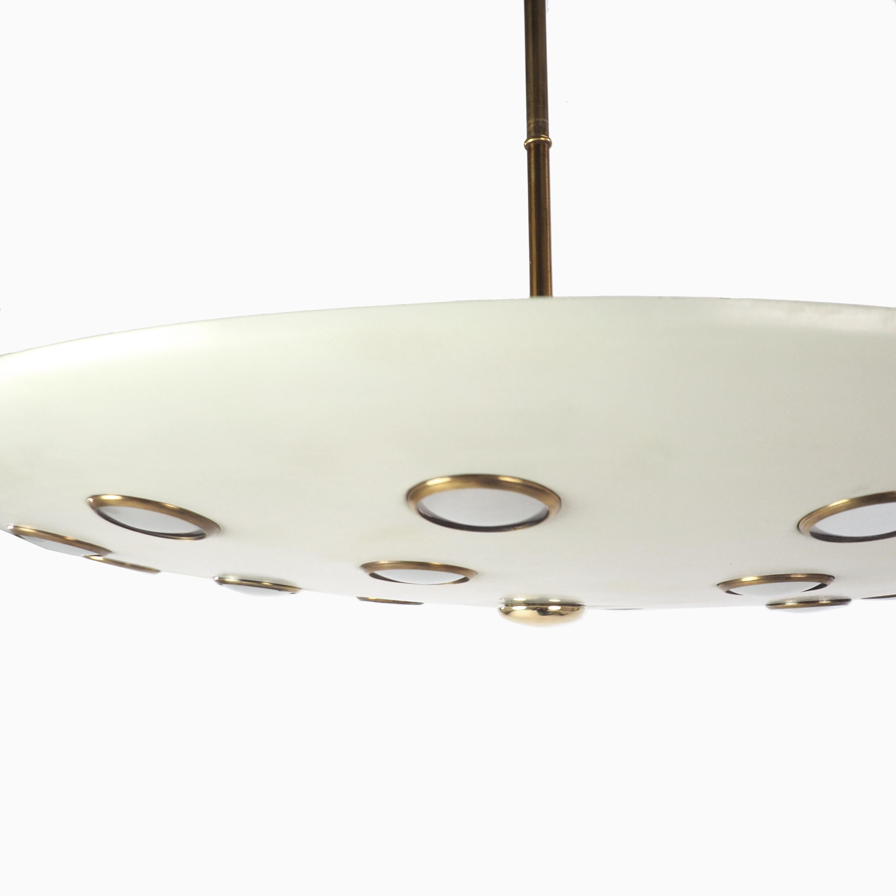 Lumen Milano midcentury Italian pendant lamp, circa 1950. Lacquered metal pendant light with a suspended dish indented with inserted brass circles and semi opaque glass lenses that diffuse light throughout the room.

Measures: L 82 x D 48 cm.