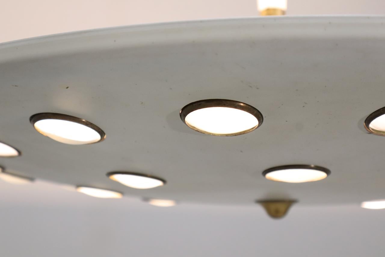Lampe suspendue italienne Lumen Milano du milieu du siècle, circa 1950. Lampe suspendue en métal laqué avec une coupelle suspendue dentelée avec des cercles en laiton insérés et des lentilles en verre semi-opaque.