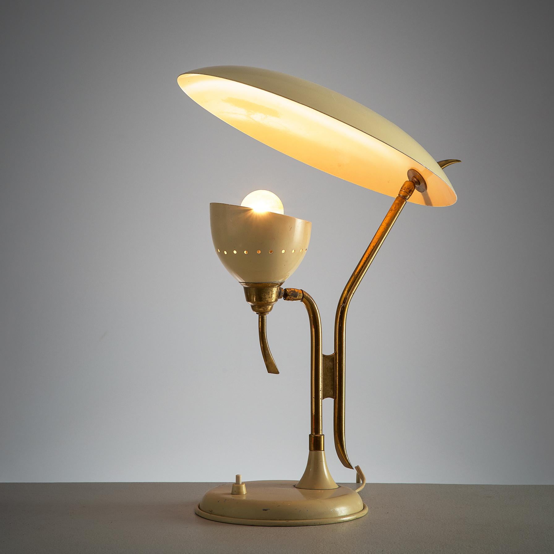 Lumen, table lamp, beige metal and brass, Italy, 1950s.

This 1950s adjustable beige desk light is manufactured by Lumen. The metal shade holding the lamp is directed upwards to another shade. This creates a beautiful diffuse light. Both shades are