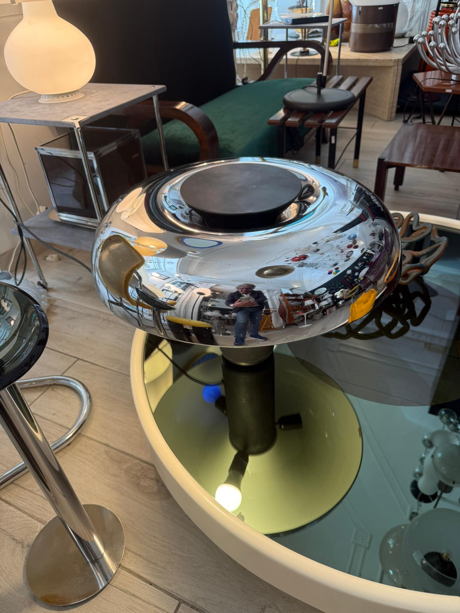 Lampada da tavolo Mod. Circa, prodotta negli anni '70 da Lumenform . L'importante paralume cromato e smaltato all'interno in color avorio, ha l'accensione a pressione sulla parte superiore tramite il grande bottone nero. La base a colonna ha un peso