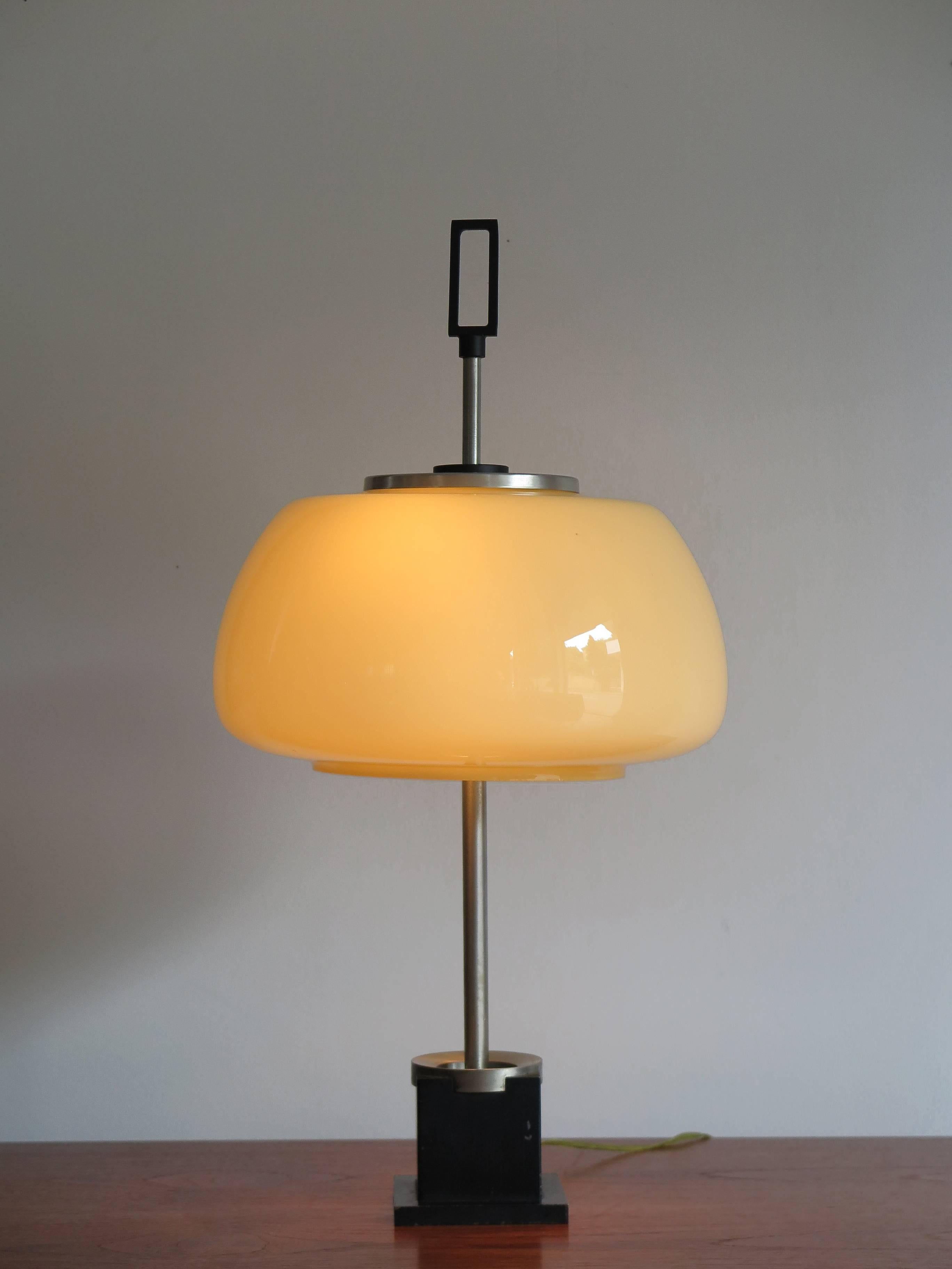 1950s Italian table lamp or desk lamp produced by Lumi with a diffuser in colored jacketed glass, base in painted cast iron and structure in matte nickel-plated brass.