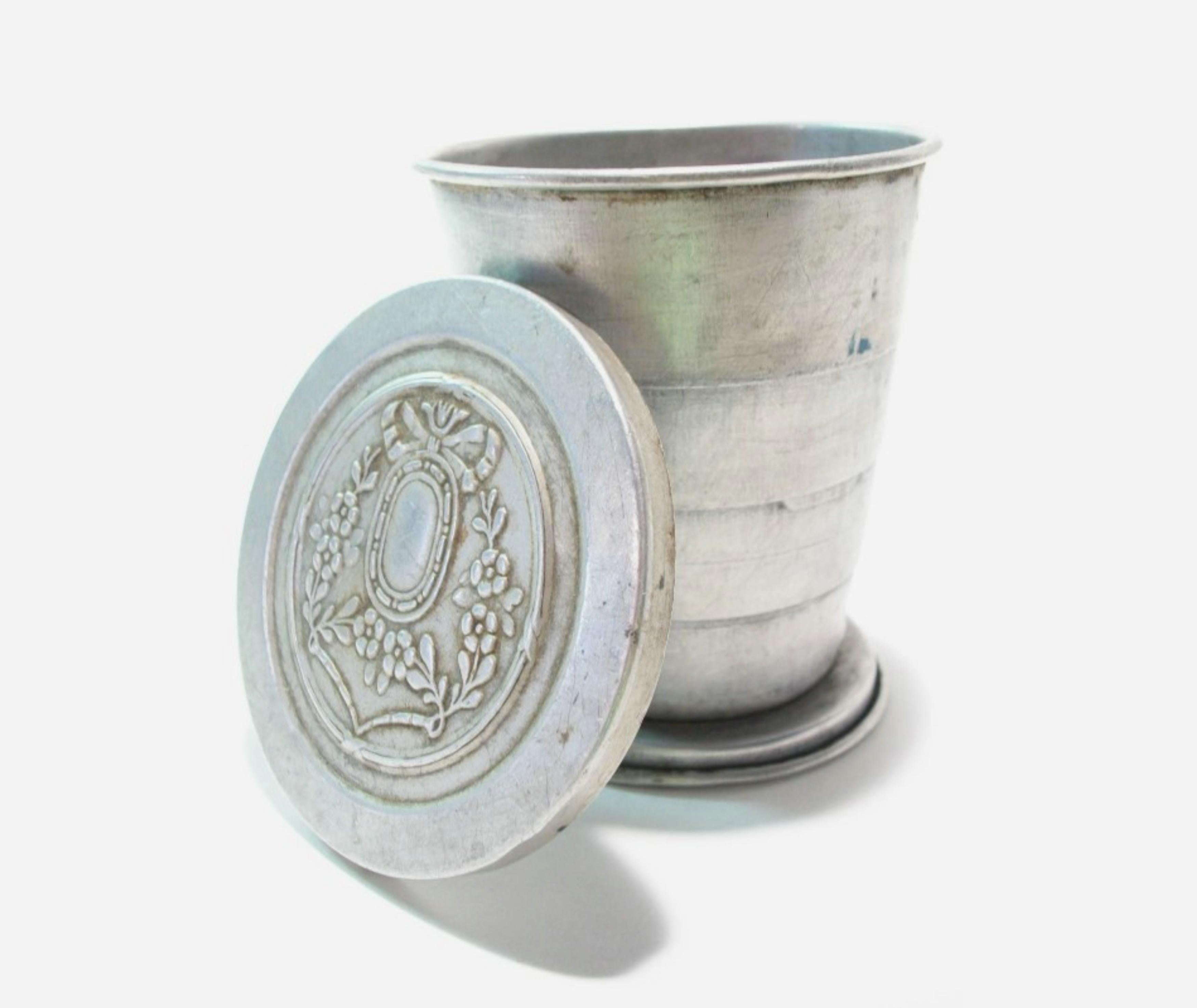 LUMIERE - Antica tazza da viaggio pieghevole con coperchio decorativo in rilievo - realizzata in alluminio leggero - firmata sulla base - Francia - circa 1895.

Eccellenti condizioni d'epoca - nessuna perdita - nessun danno - graffi superficiali e