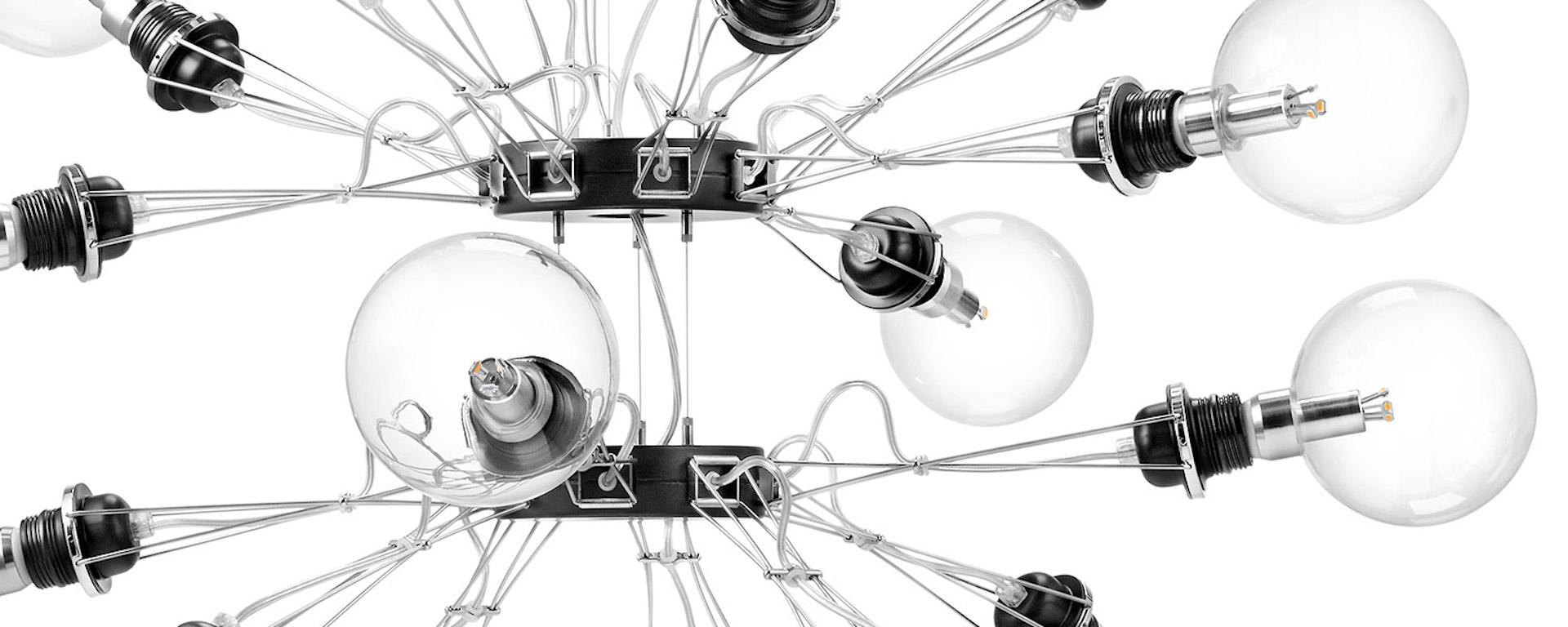 Lampada a sospensione in lega di alluminio e acciaio composta da un corpo centrale con sedici bracci che possono essere spostati verticalmente; è possibile utilizzare lampadine alogene o fluorescenti compatte entro la potenza massima ammessa.
Le