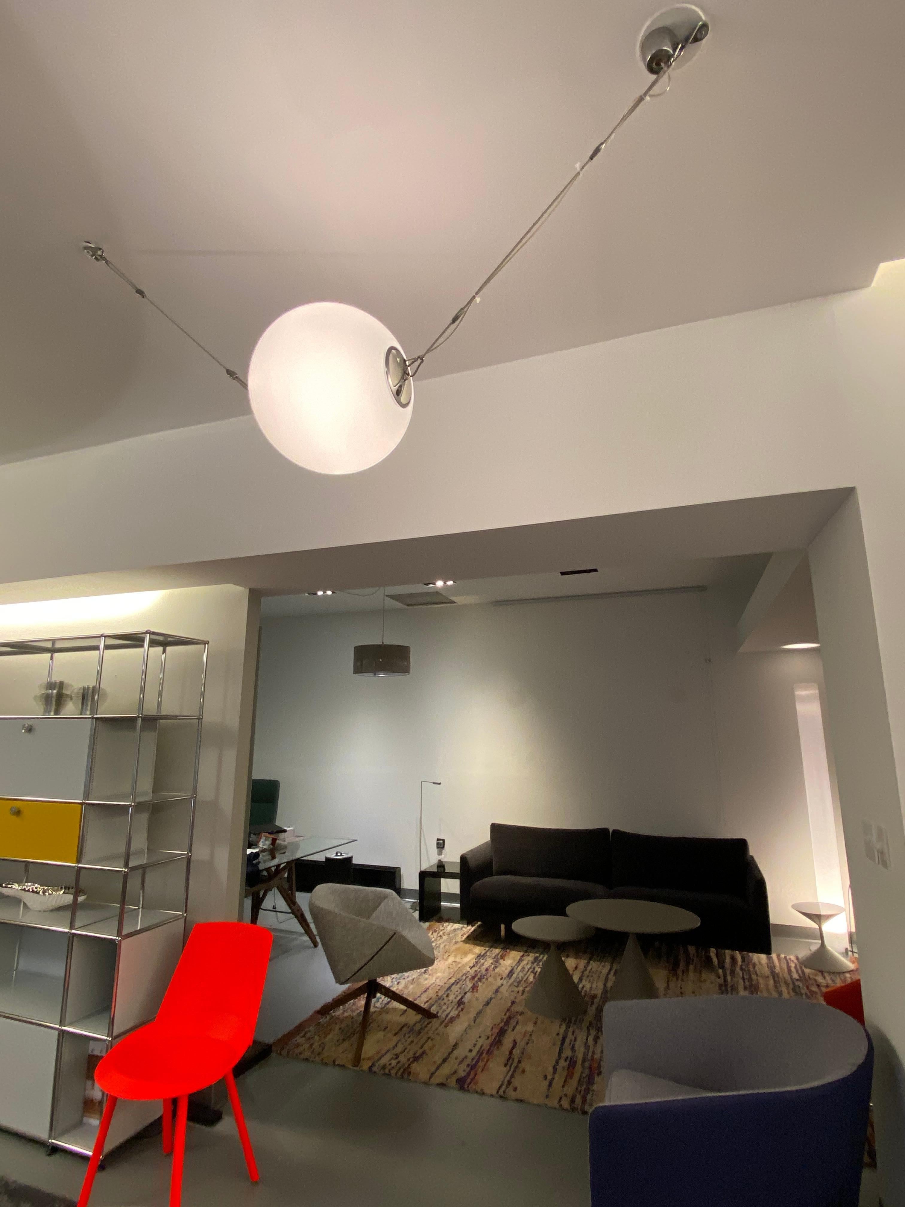 A suspended light fitting for diffused illumination, made of die-cast aluminium with a diffuser of blown glass, available in 2 sizes and powers. Possibility of cascaded installations since you can electrically connect several fittings to the same