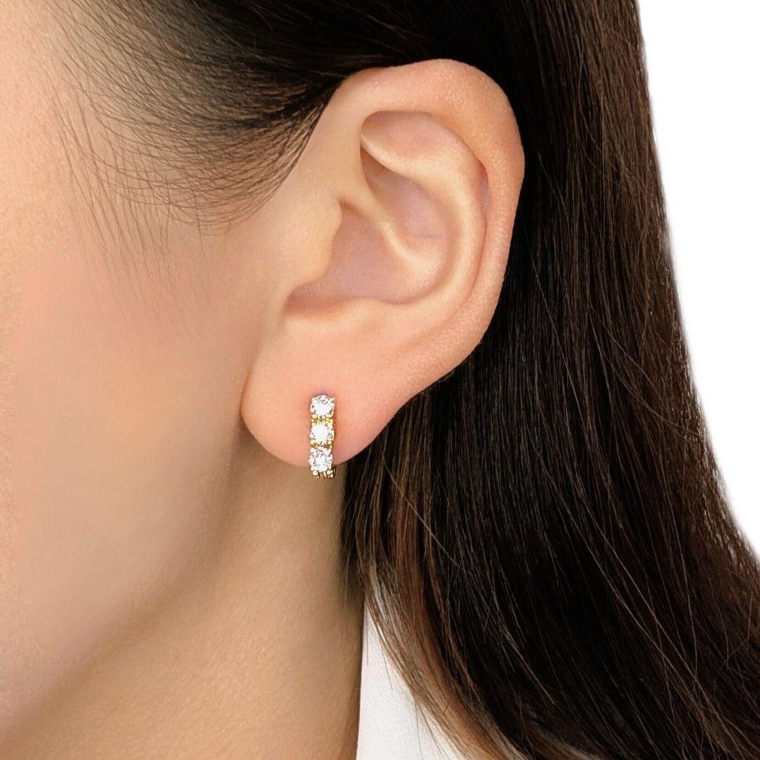 Ornez vos oreilles de l'élégance intemporelle de ces boucles d'oreilles à 3 pierres, méticuleusement réalisées en or jaune 18 carats rayonnant. Chaque boucle d'oreille est ornée d'un brillant trio de diamants ronds naturels, d'une valeur totale